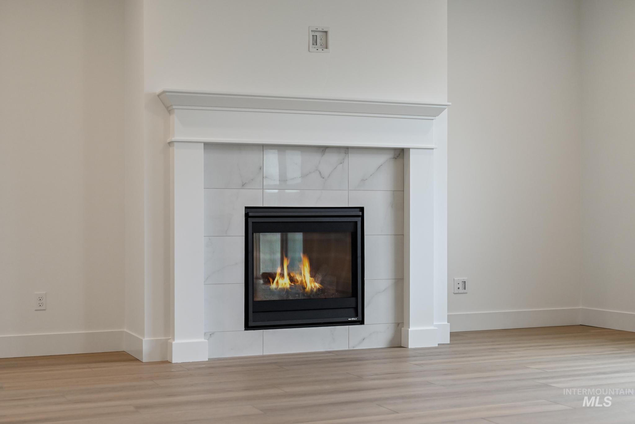 Detailed view of wood finished floors and a tile fireplace