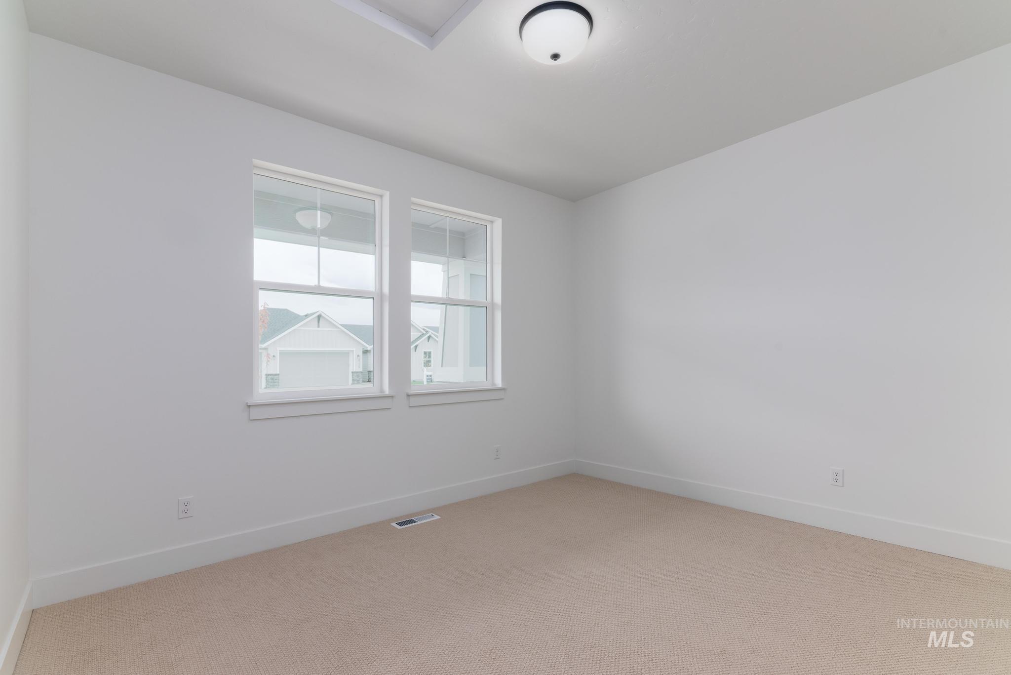 Unfurnished room with baseboards and light carpet
