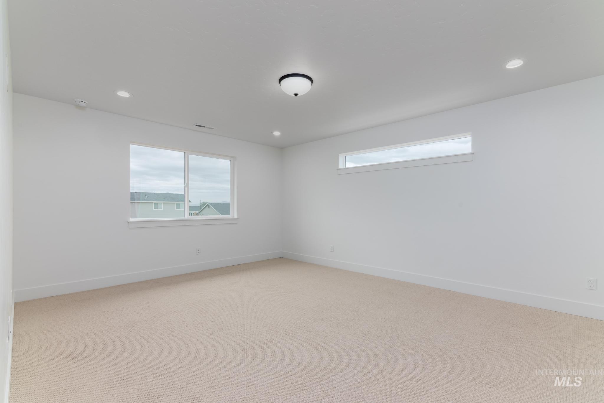 Empty room featuring light carpet and recessed lighting