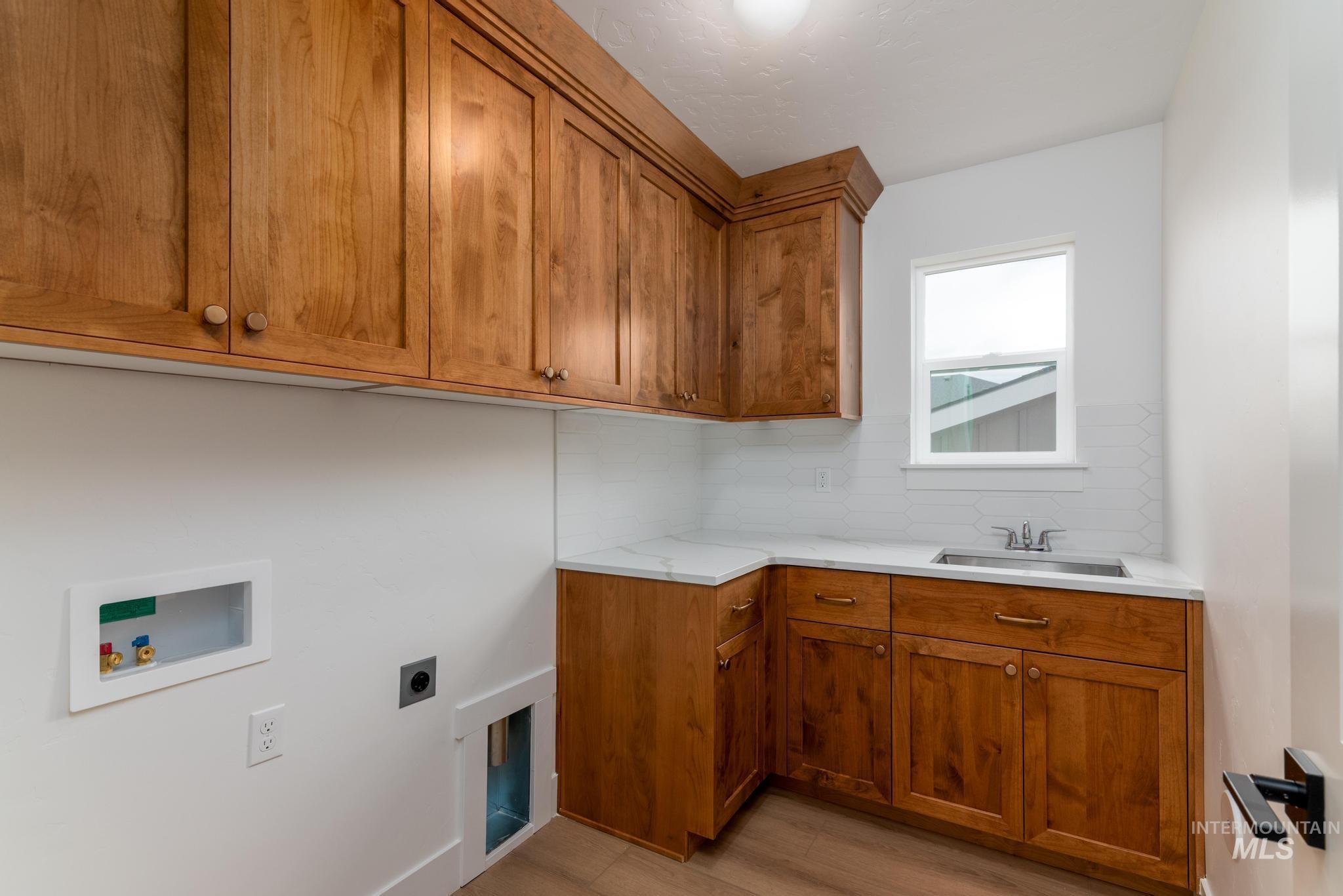 Laundry room featuring washer hookup, light wood-style floors, cabinet space, and electric dryer hookup