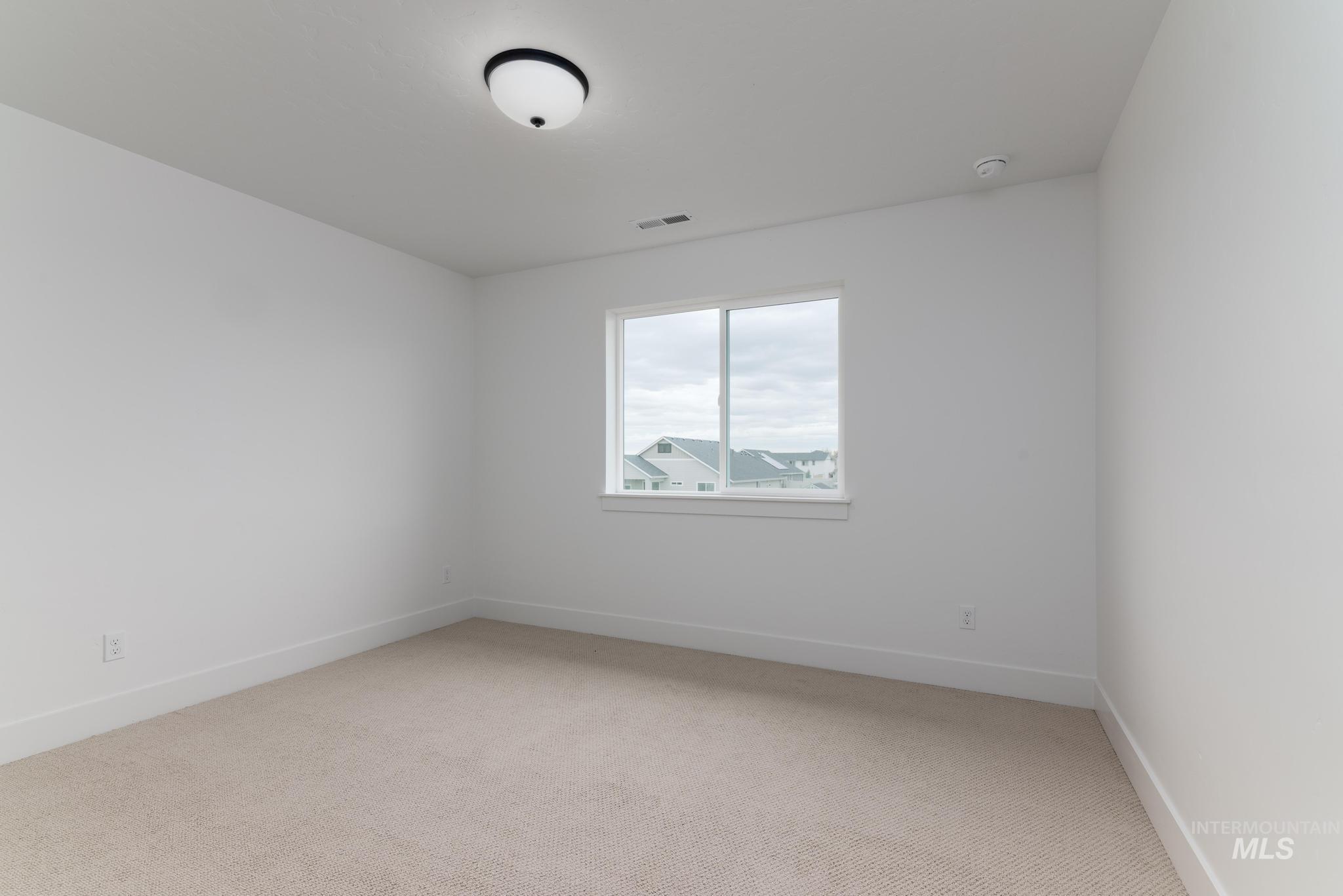 Empty room with light carpet and baseboards