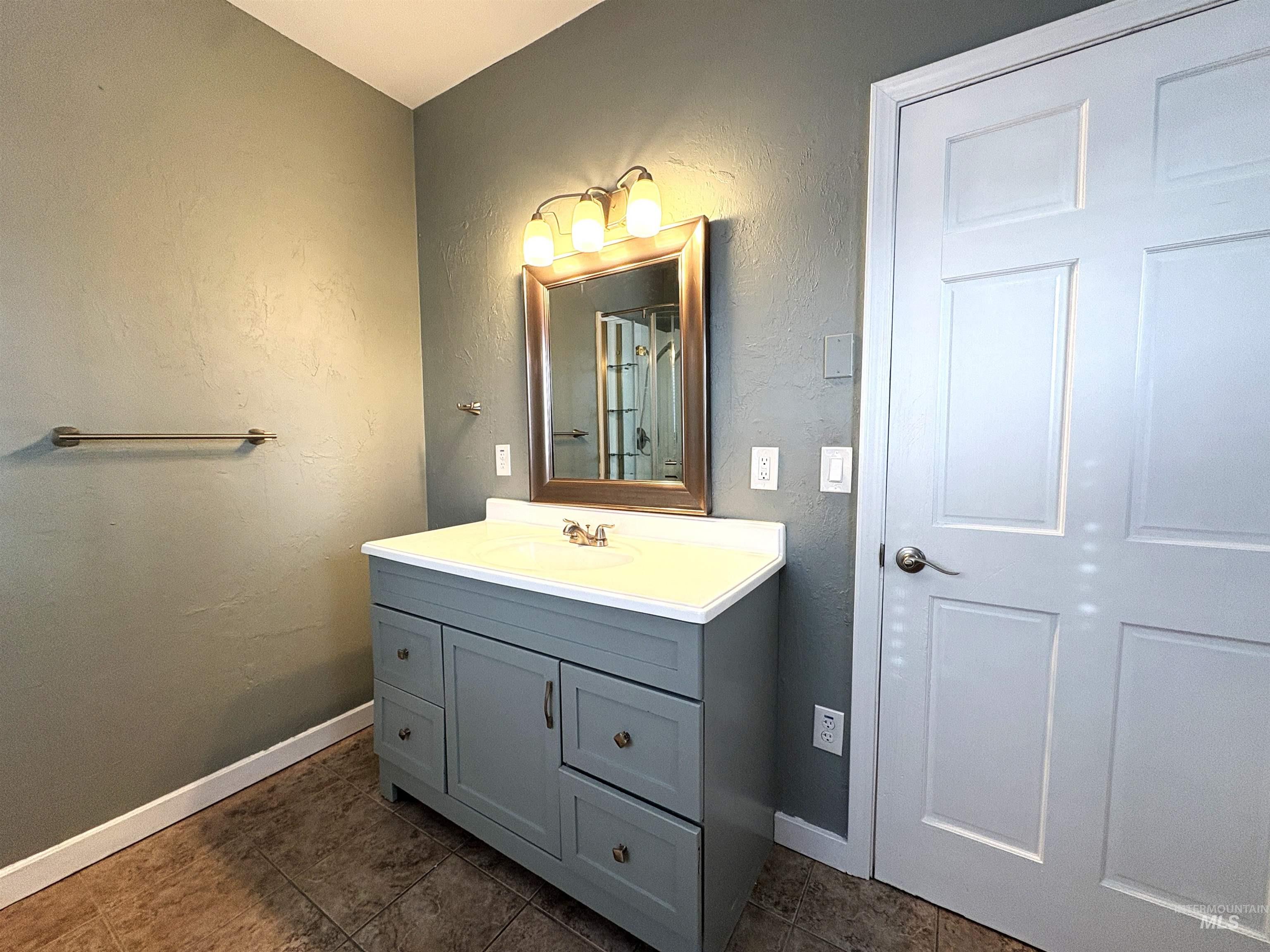 Bathroom with a textured wall and vanity.