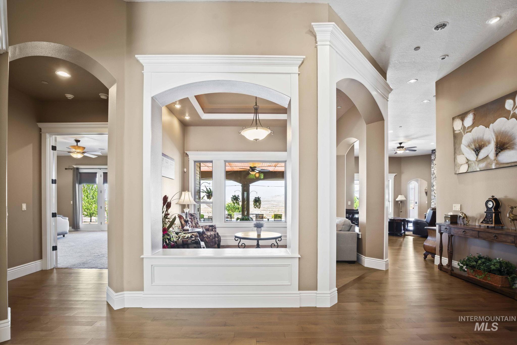 Foyer with a ceiling fan, wood finished floors, recessed lighting, and arched walkways