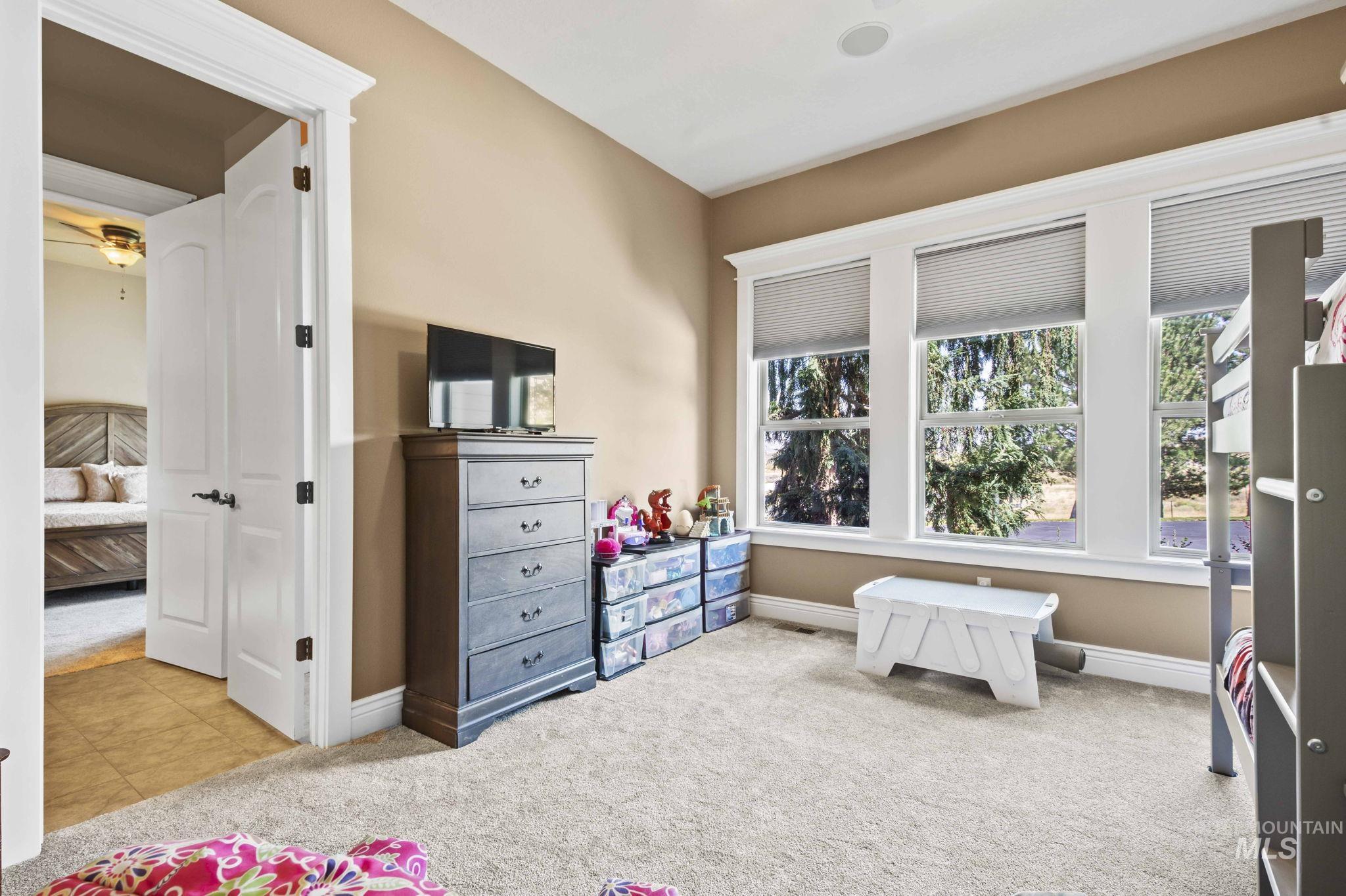Carpeted bedroom featuring multiple windows