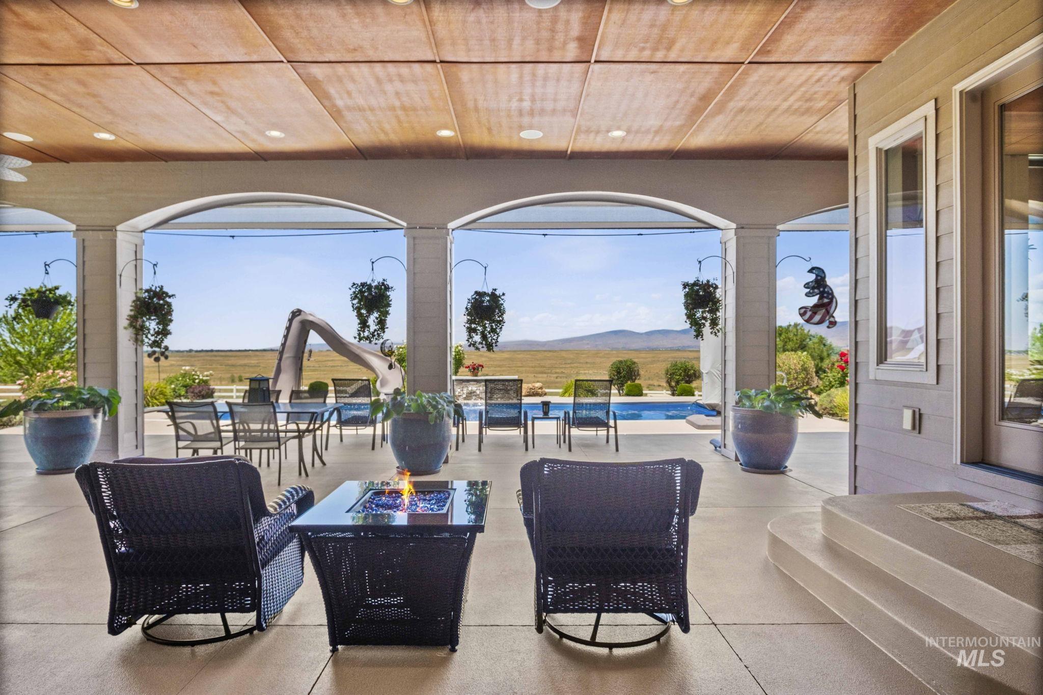 View of patio with a mountain view, an outdoor fire pit, and an outdoor pool