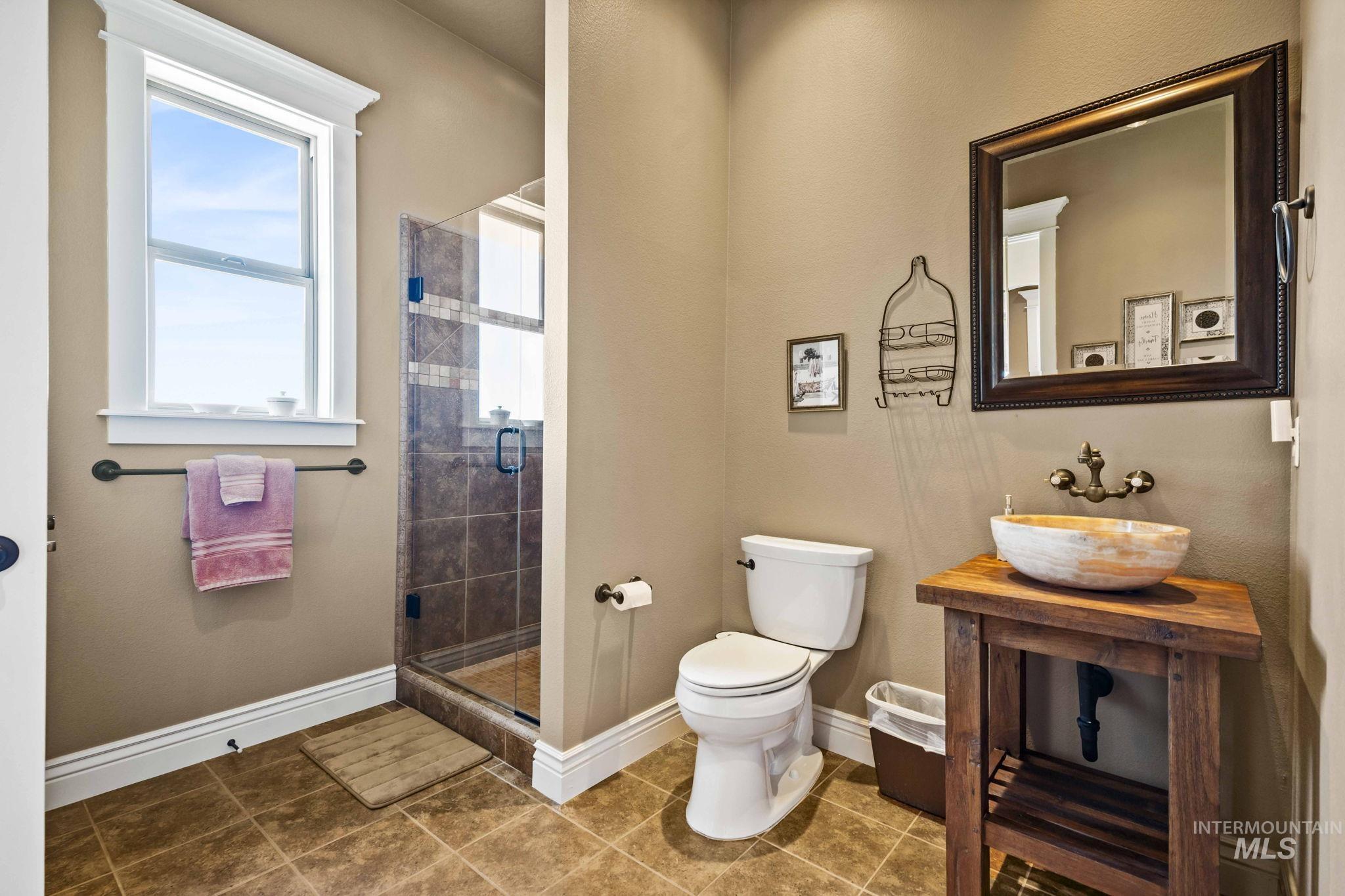 Bathroom with a stall shower and tile patterned floors