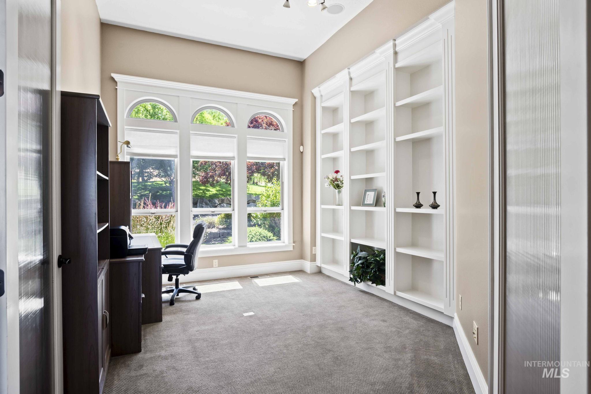 Office space with built in shelves and carpet floors