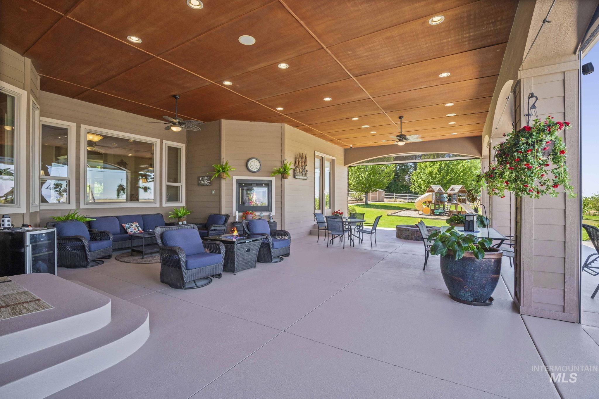 View of patio / terrace with a ceiling fan, an outdoor living space with a fire pit, and outdoor dining area