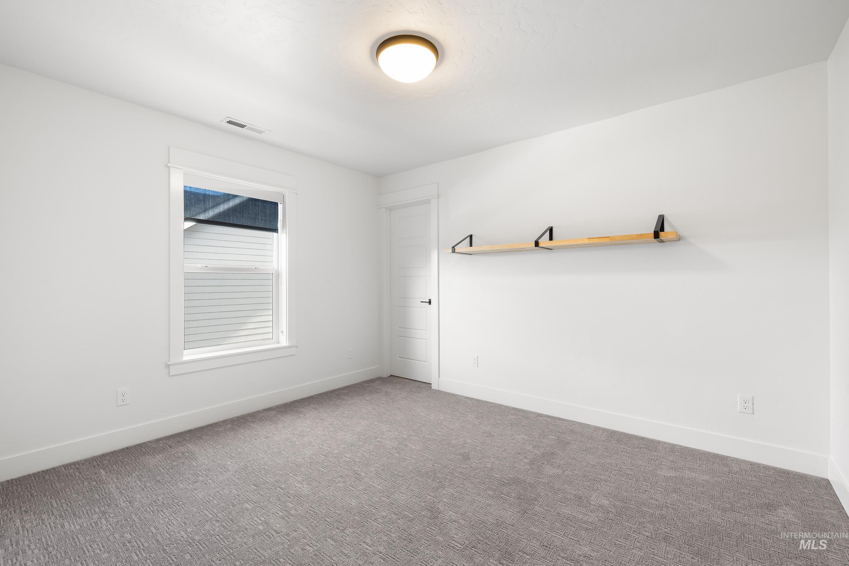 Spare room with carpet and baseboards