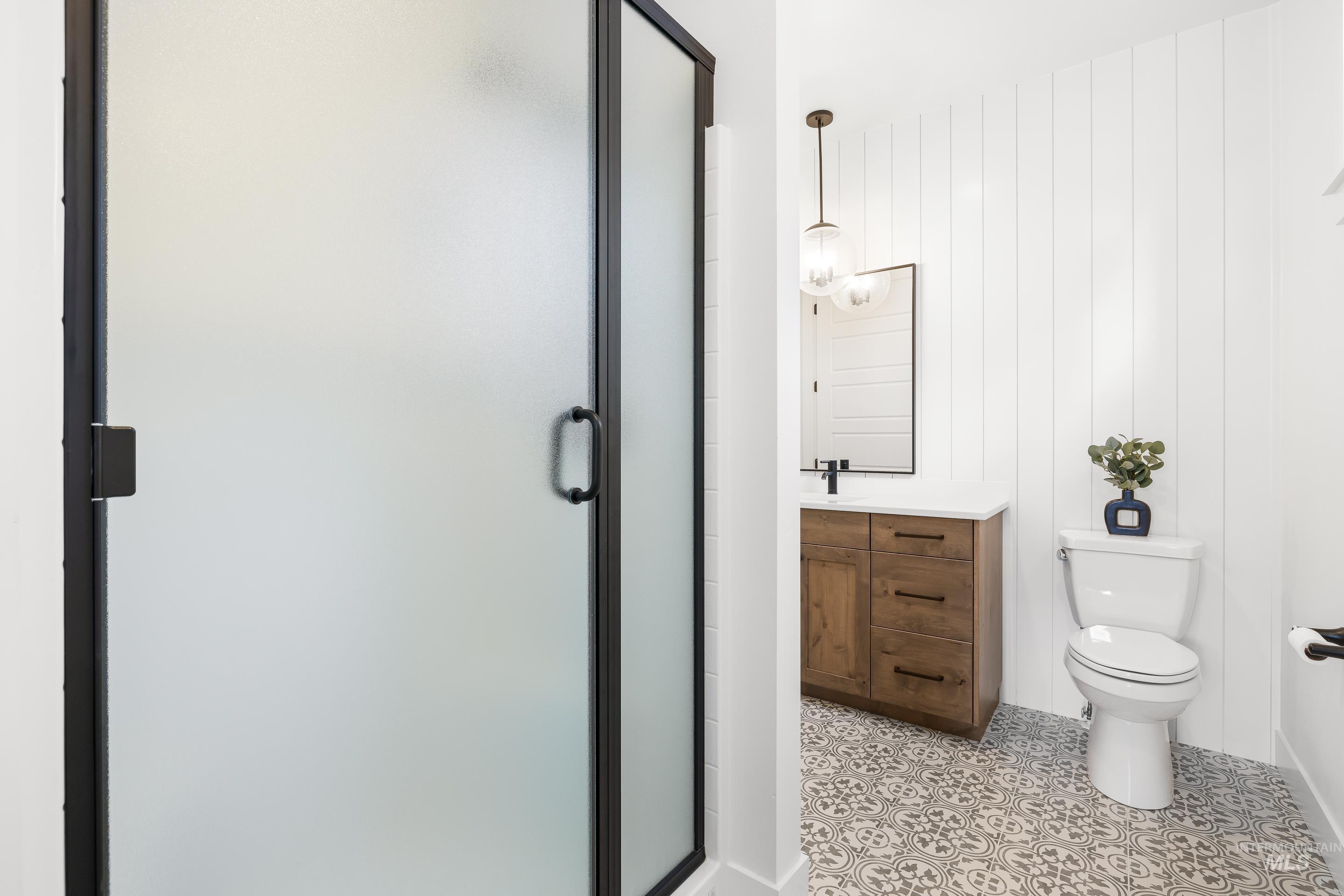 Full bathroom with a shower stall, vanity, and light tile patterned flooring