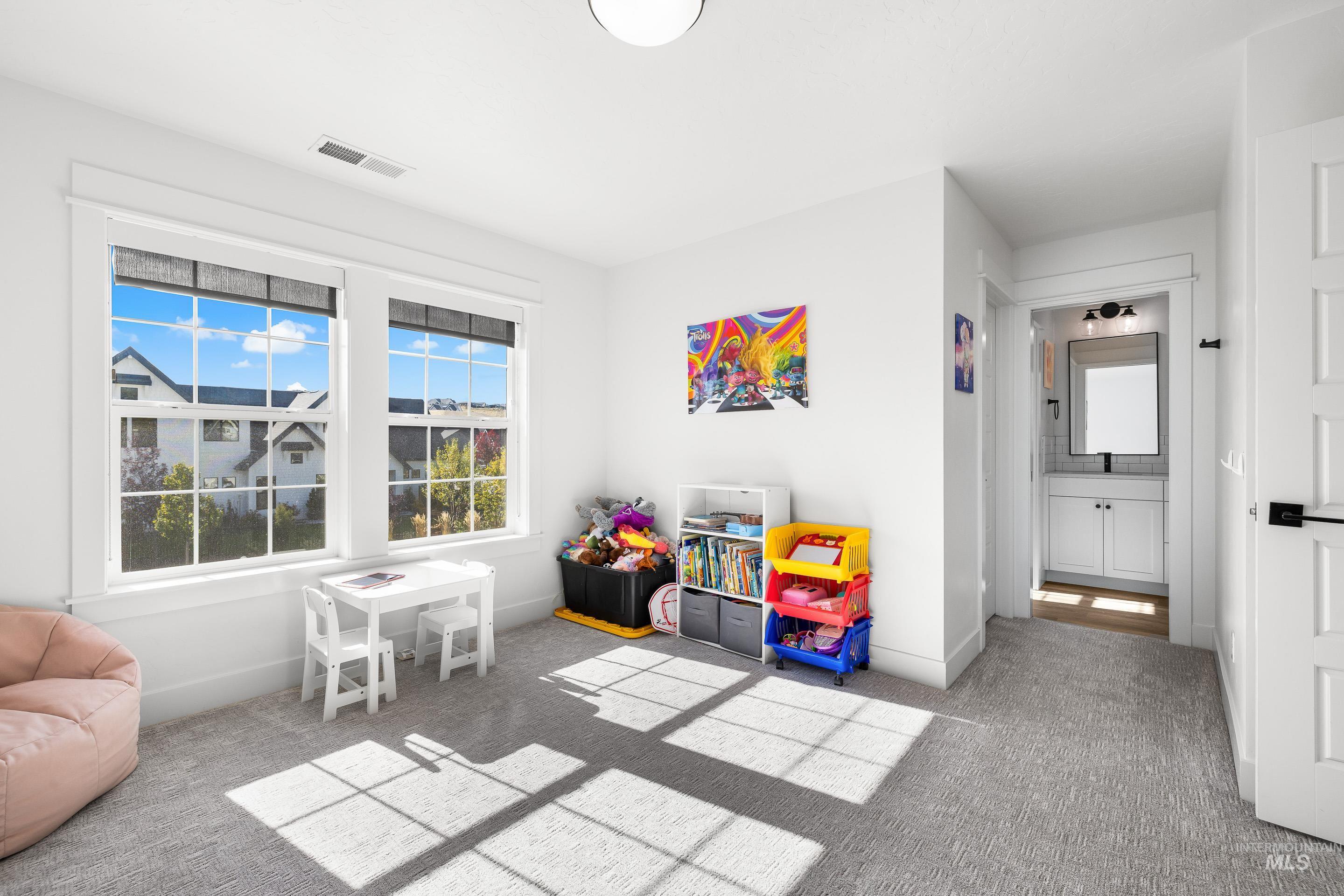 Recreation room with light carpet and baseboards