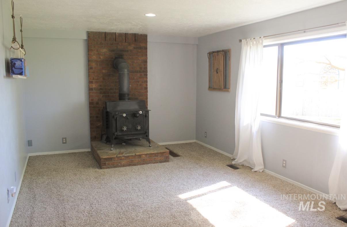 Freestanding wood-burning stove with a brick hearth and backing