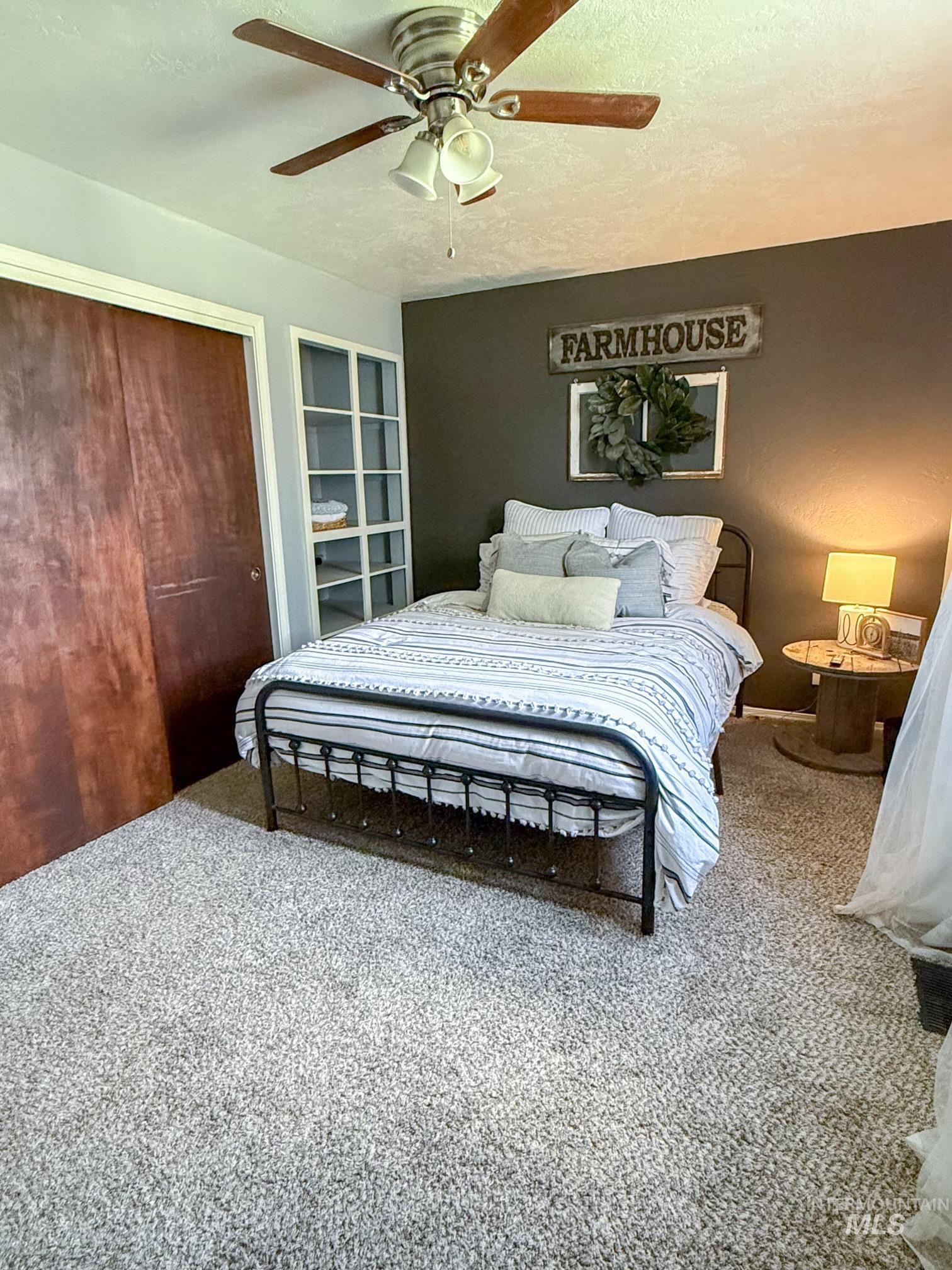 Plush carpeting throughout with a built-in bookcase and a ceiling fan with light fixture