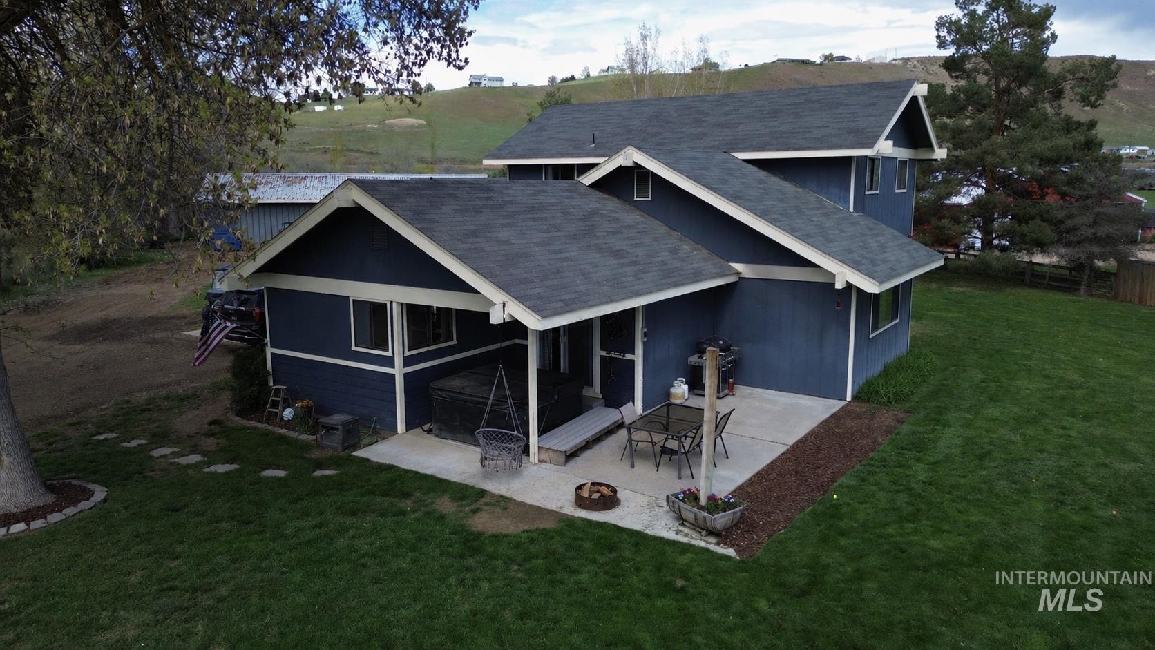 Contemporary residence featuring dark blue siding with contrasting white trim, a dark shingle roof, and multiple gables