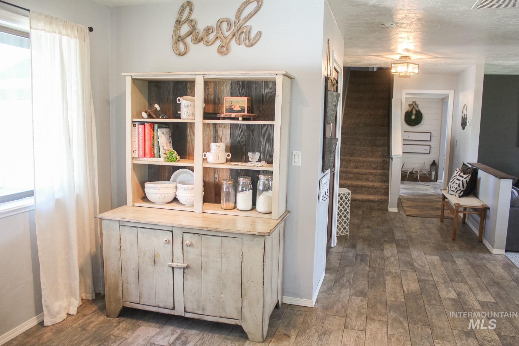 Built-in shelving unit with distressed wood-finish paneling and cabinet storage, set on wood-finish flooring