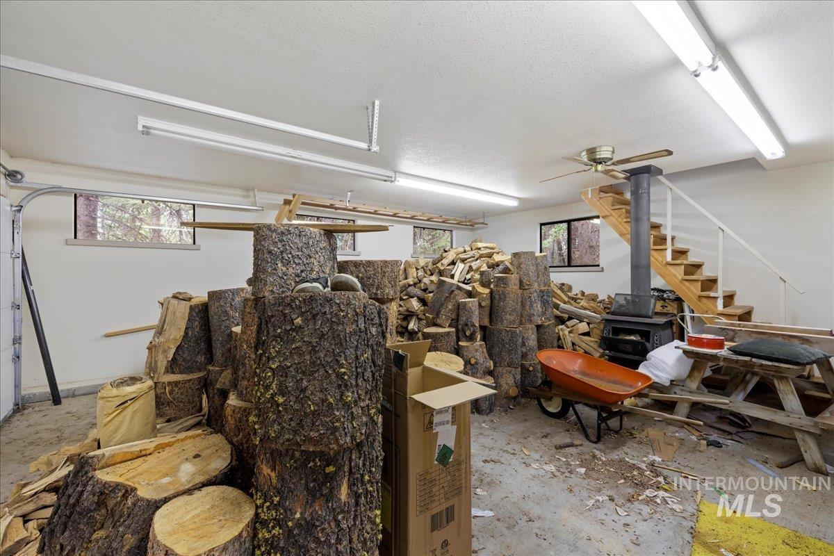 Garage with a wood stove and ceiling fan