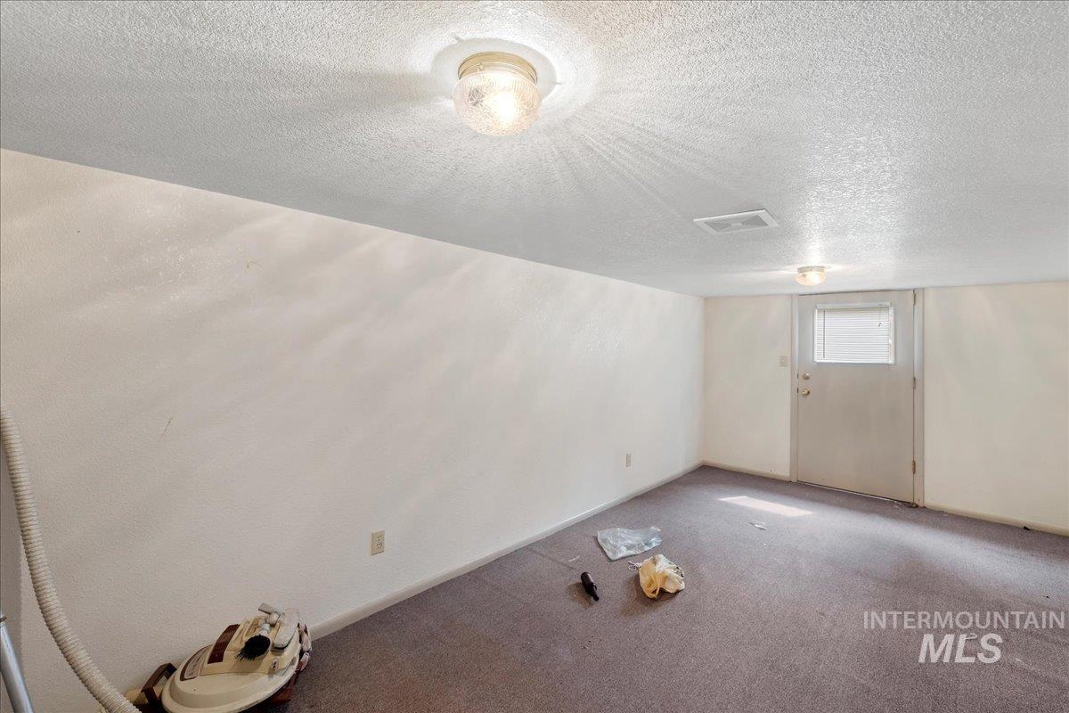 Basement featuring a textured ceiling and carpet