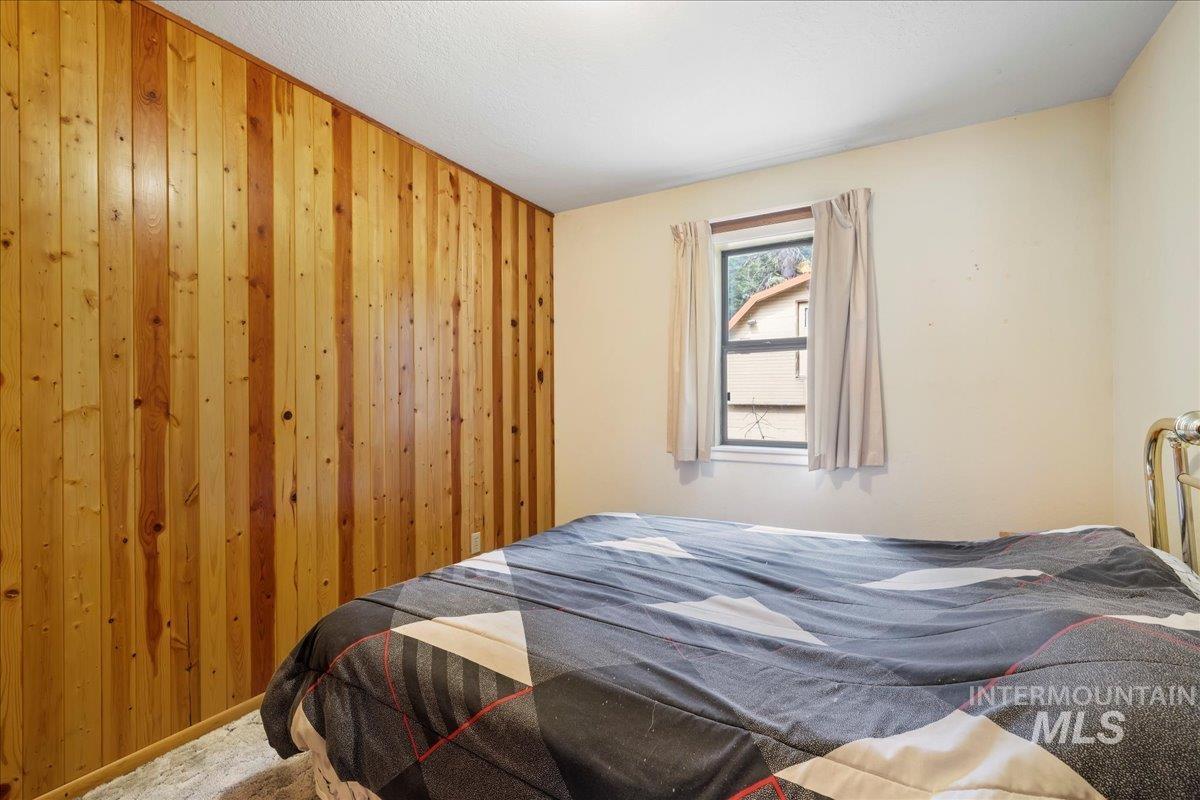 Bedroom with wood walls and carpet floors