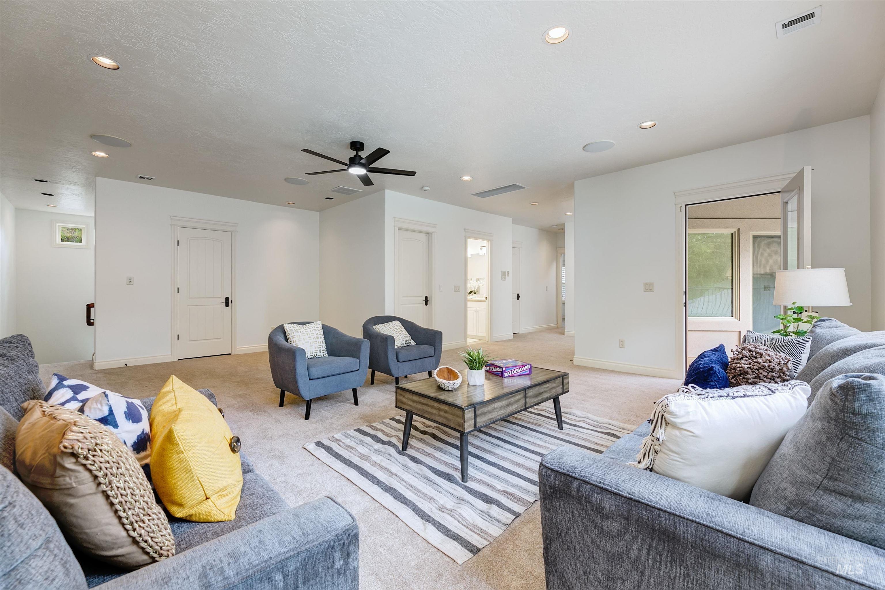 Carpeted living area featuring a ceiling fan and recessed lighting