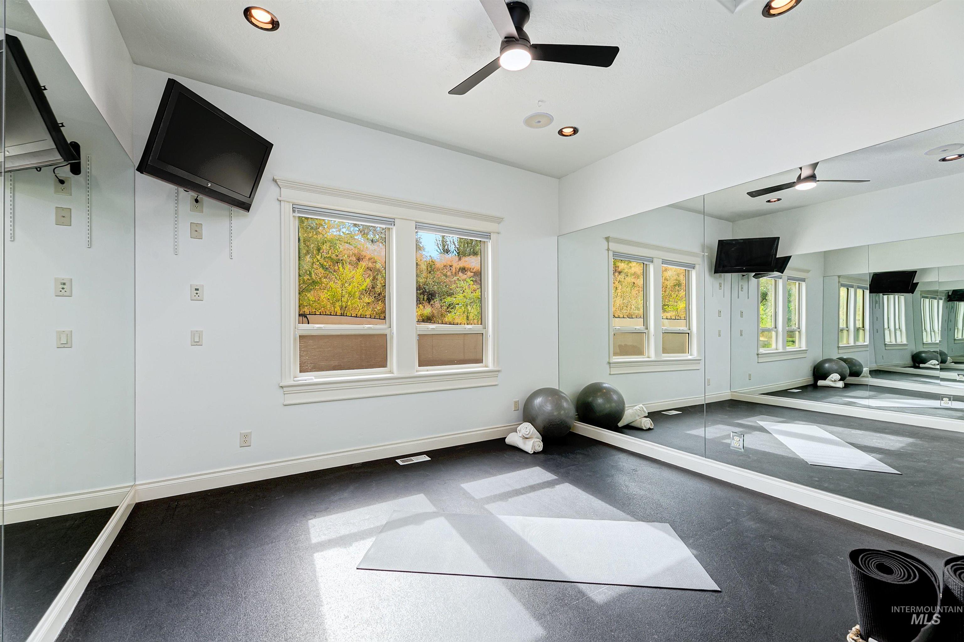 Workout area featuring a ceiling fan, healthy amount of natural light, and recessed lighting