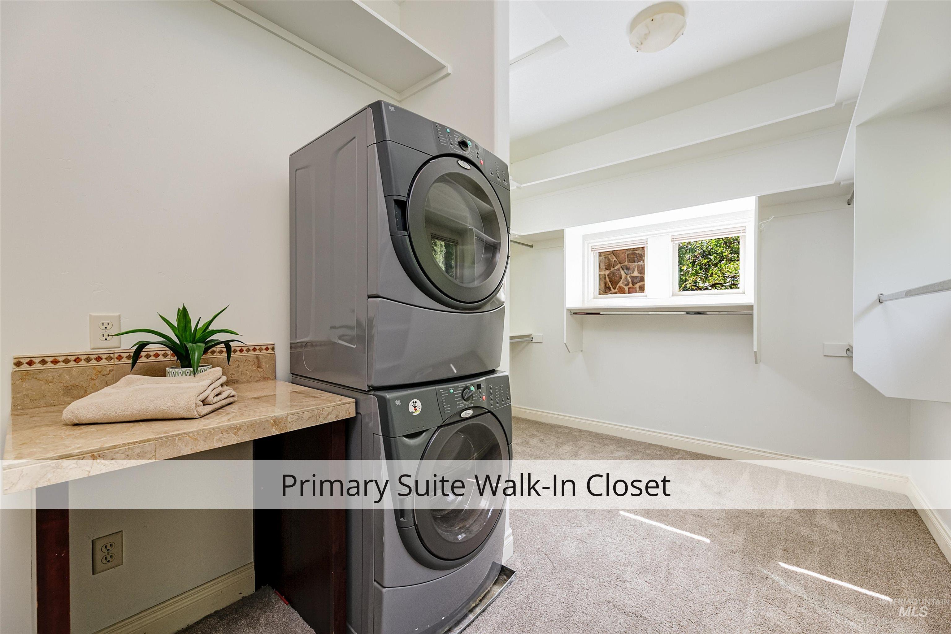 Laundry area with light colored carpet and stacked washer and dryer