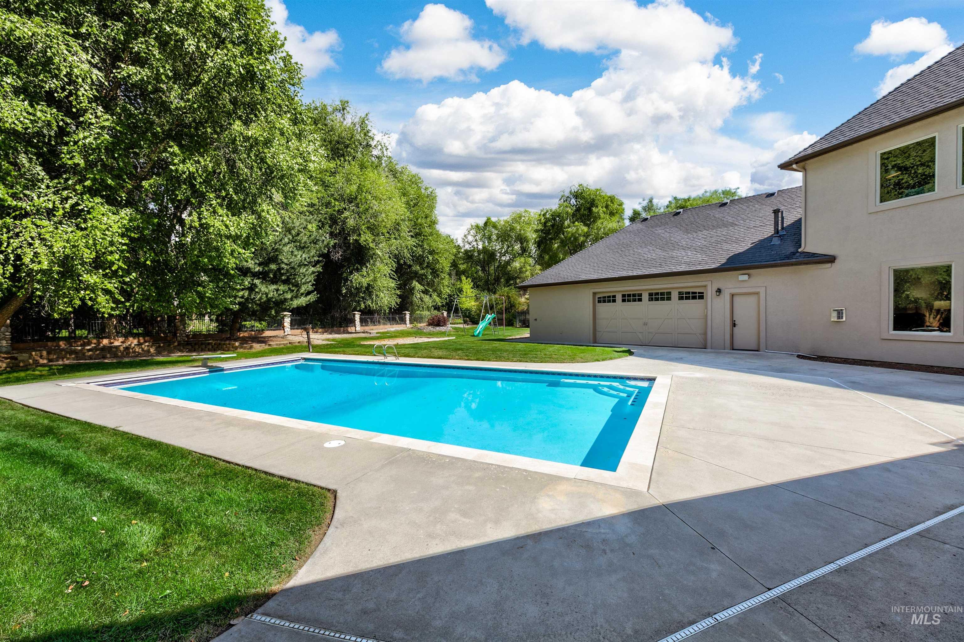 View of swimming pool featuring a diving board and a playground