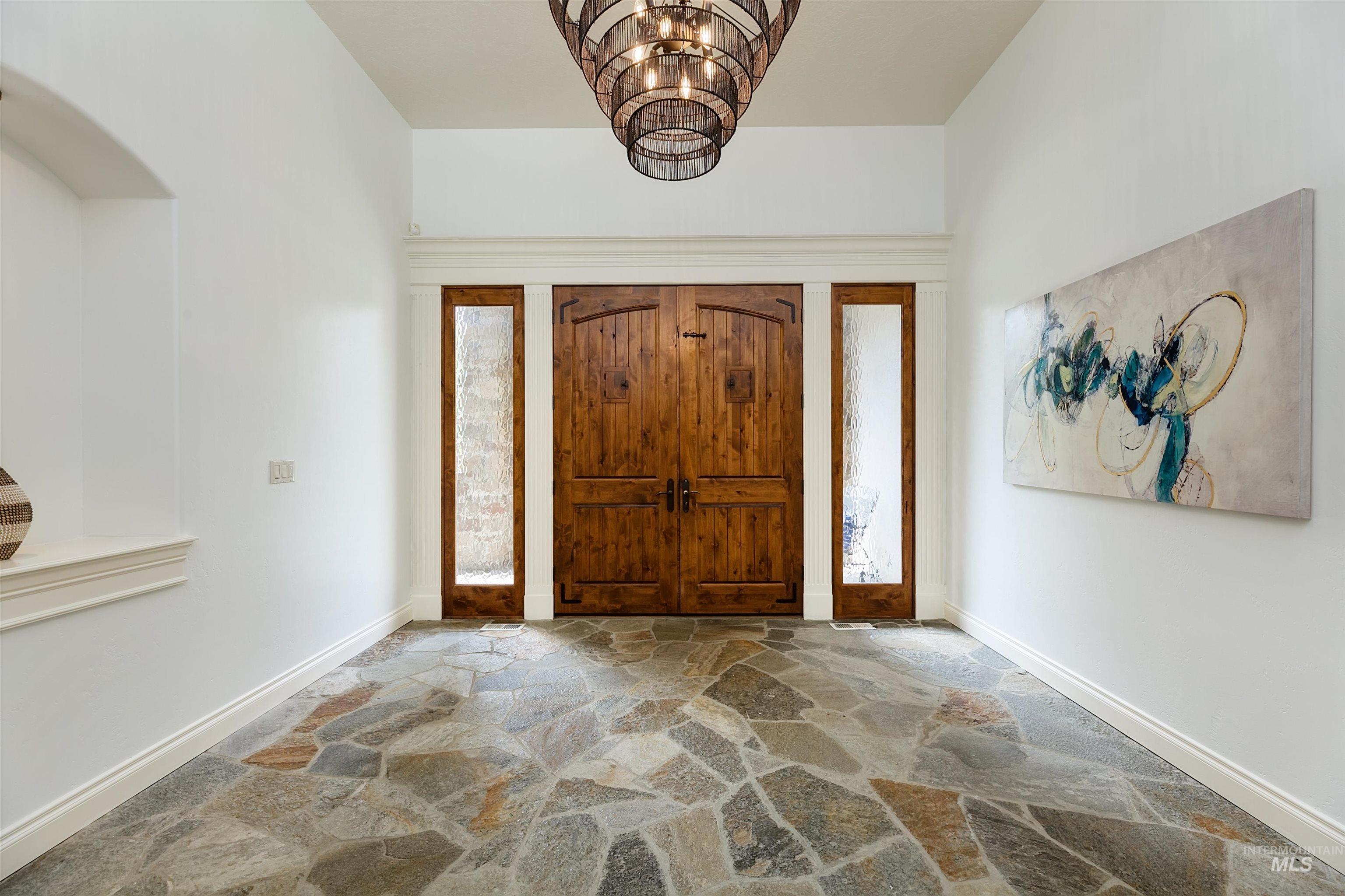 Entryway featuring stone flooring and suspended lighting