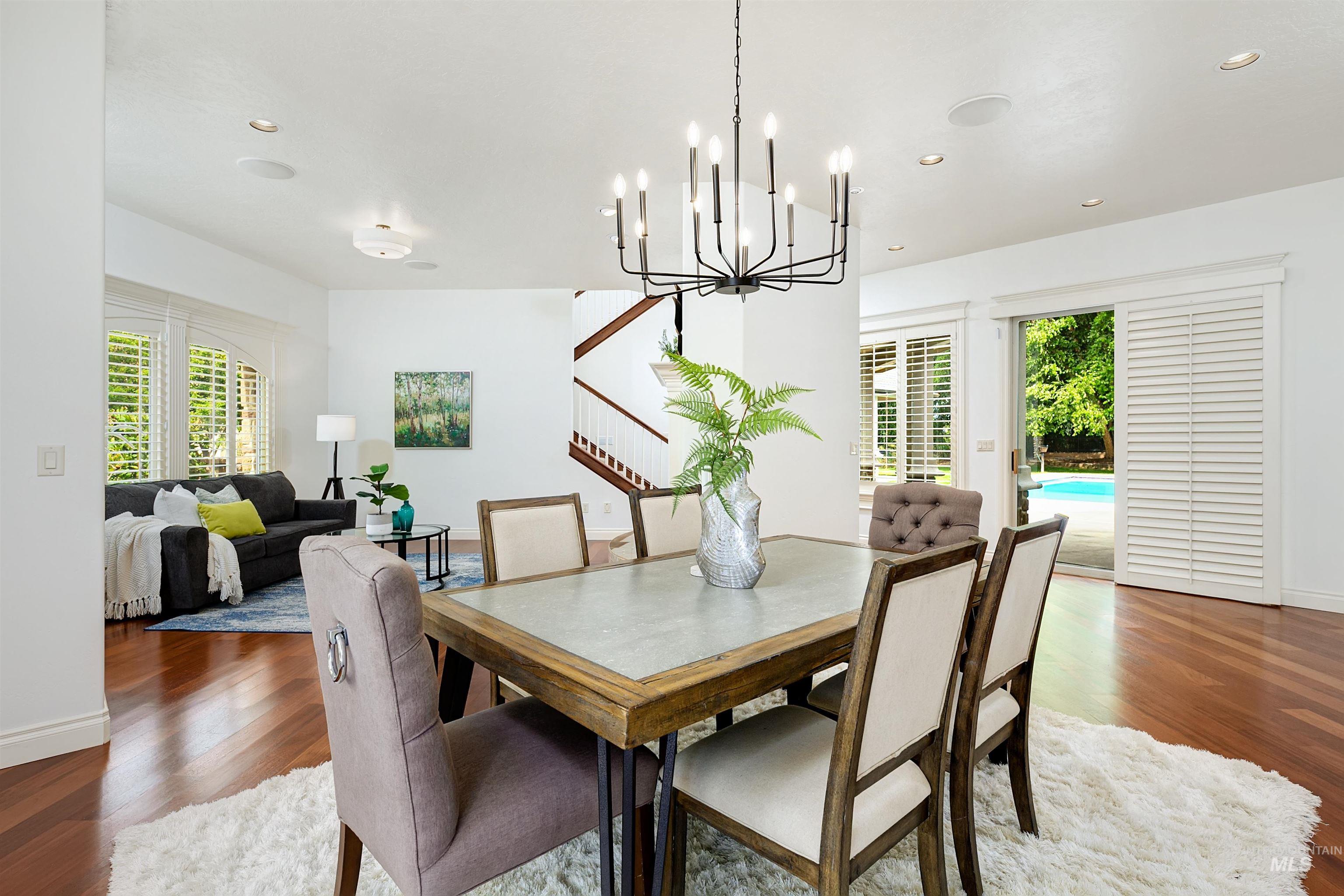 Dining room featuring wood finished floors, a chandelier, and healthy amount of natural light