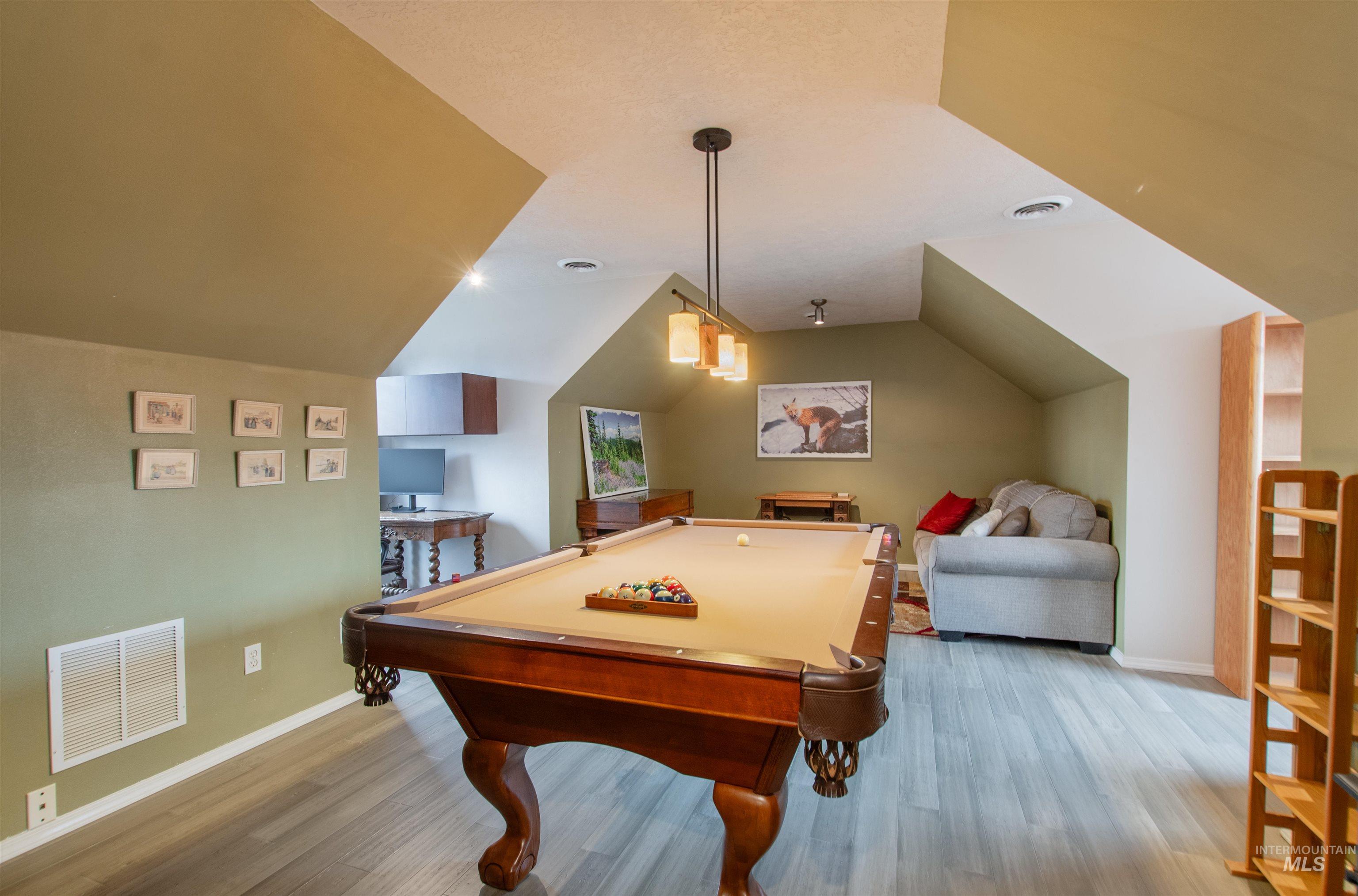 Game room featuring billiards, light wood-style floors, and lofted ceiling