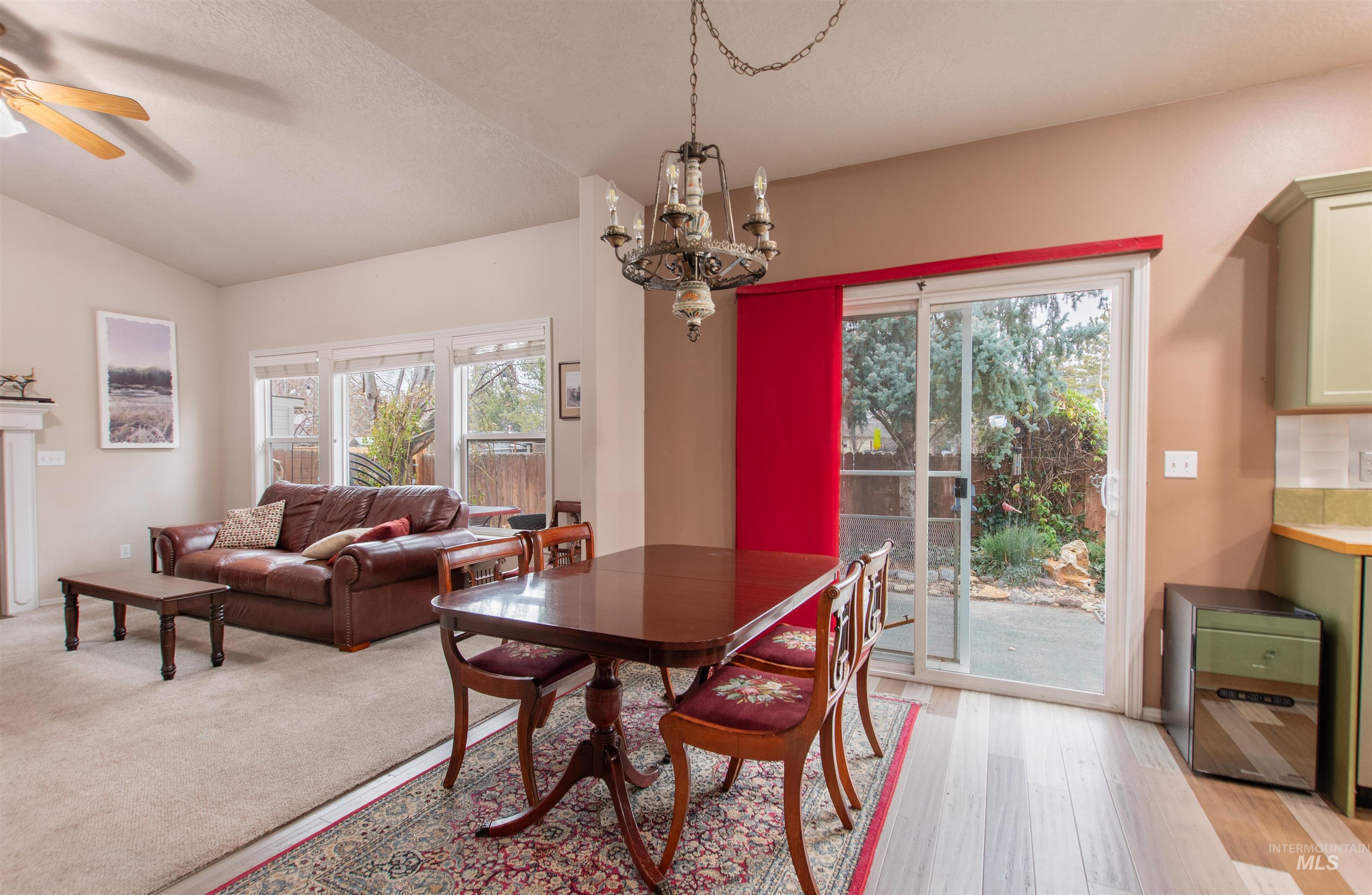 Dining area with a ceiling fan, hanging lights, healthy amount of natural light, and light wood-style floors
