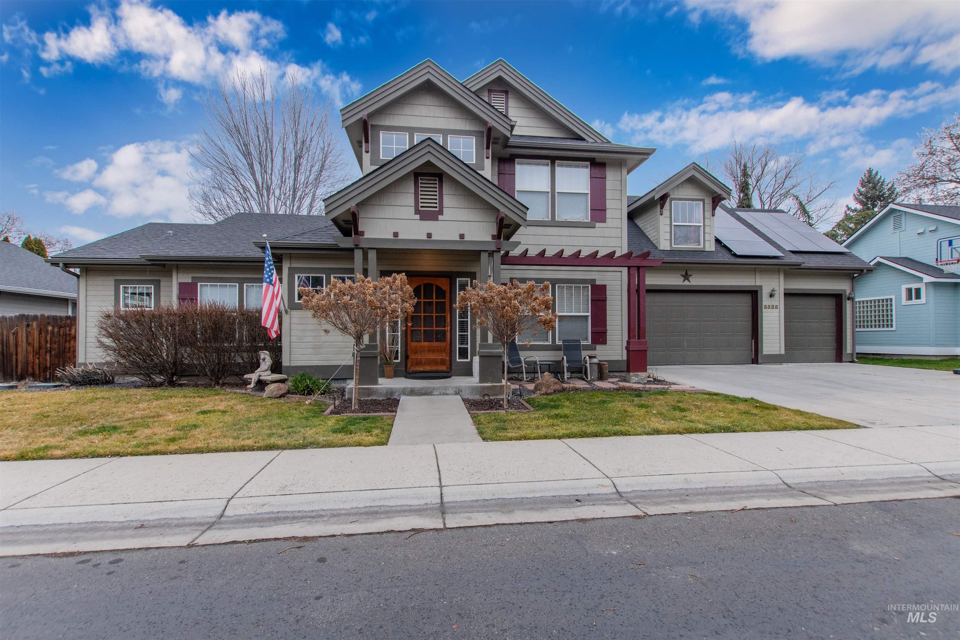View of front of house with concrete driveway, a front lawn, an attached garage, and covered porch