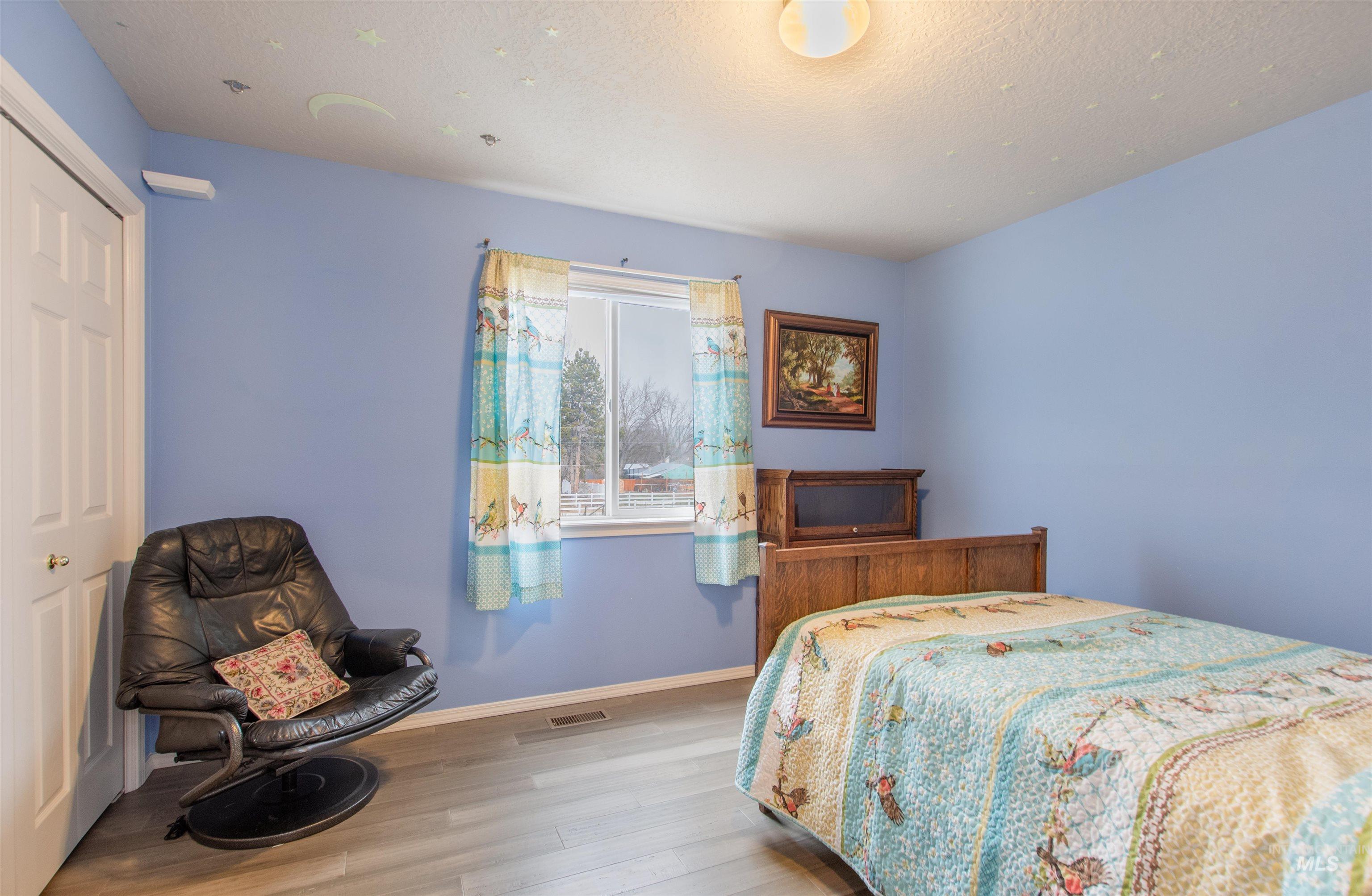 Bedroom featuring wood finished floors and a closet
