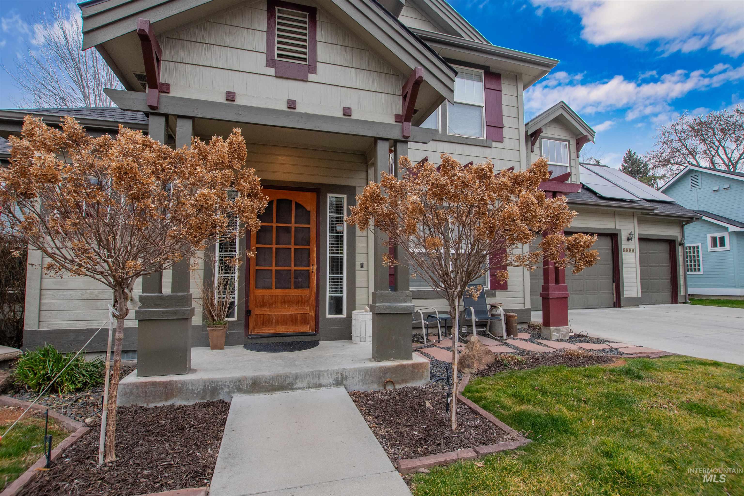 View of front of home with solar panels and driveway