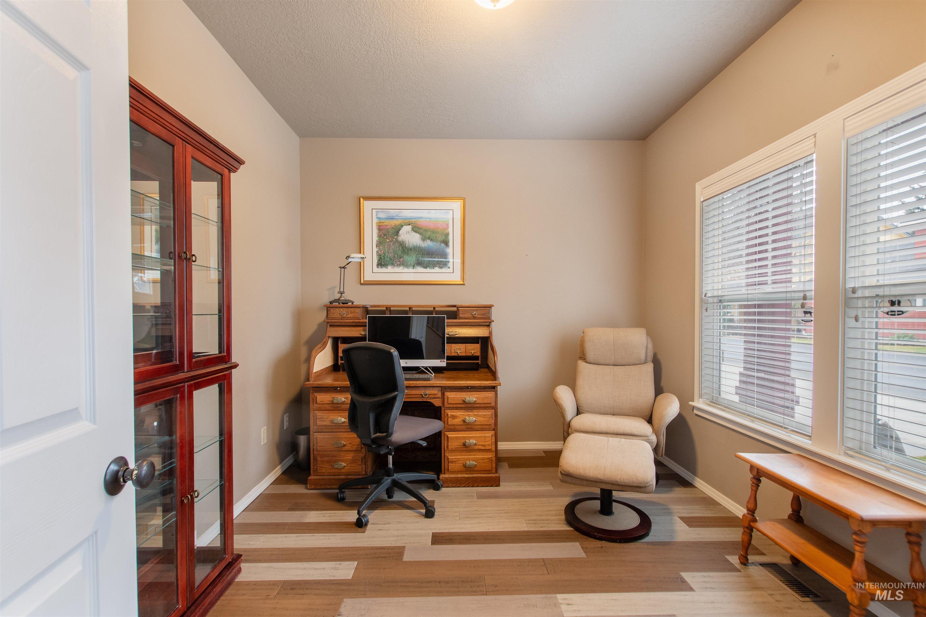 Home office with baseboards and light wood-style floors