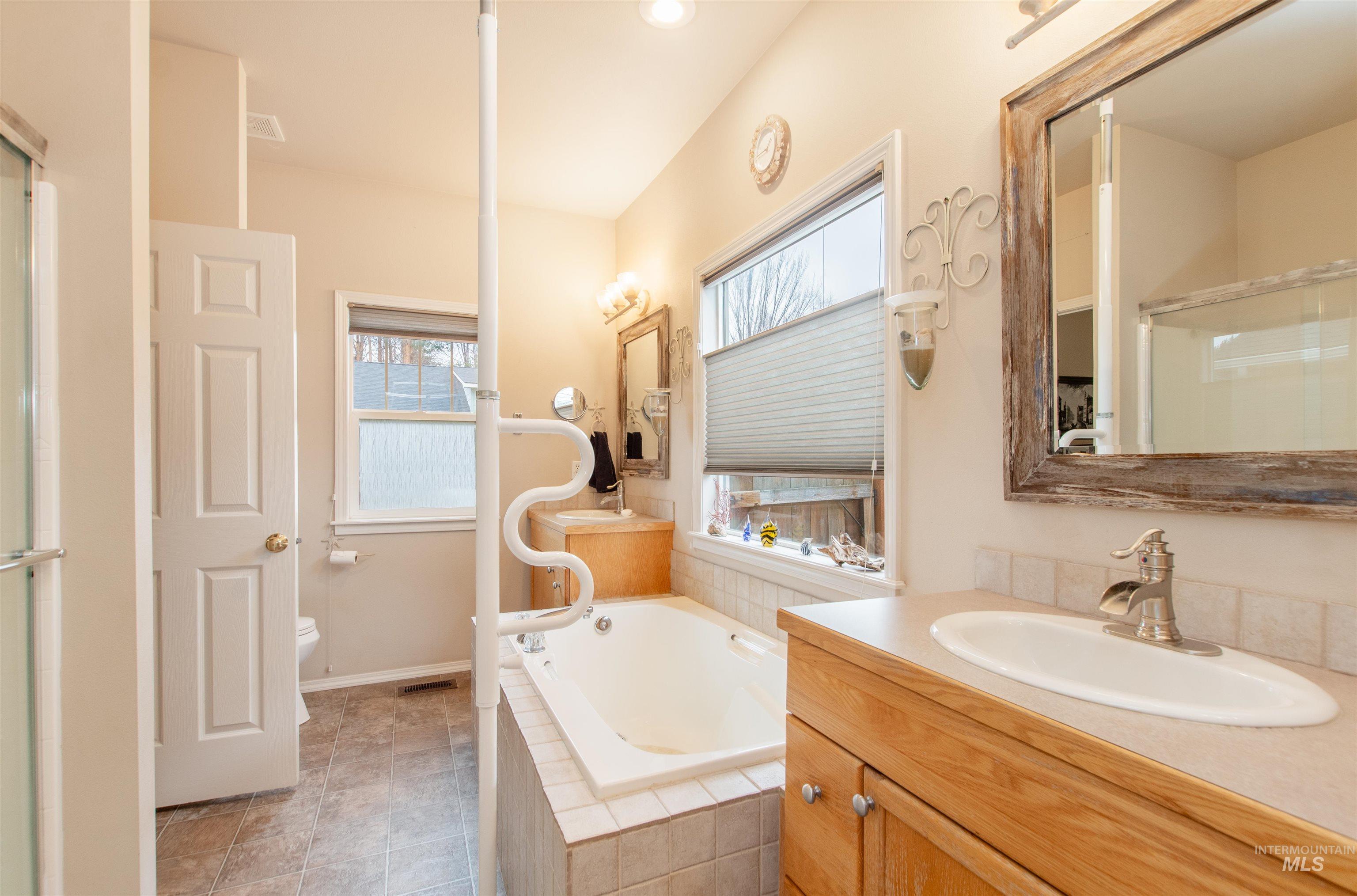 Full bathroom with a bath, vanity, and a shower with door