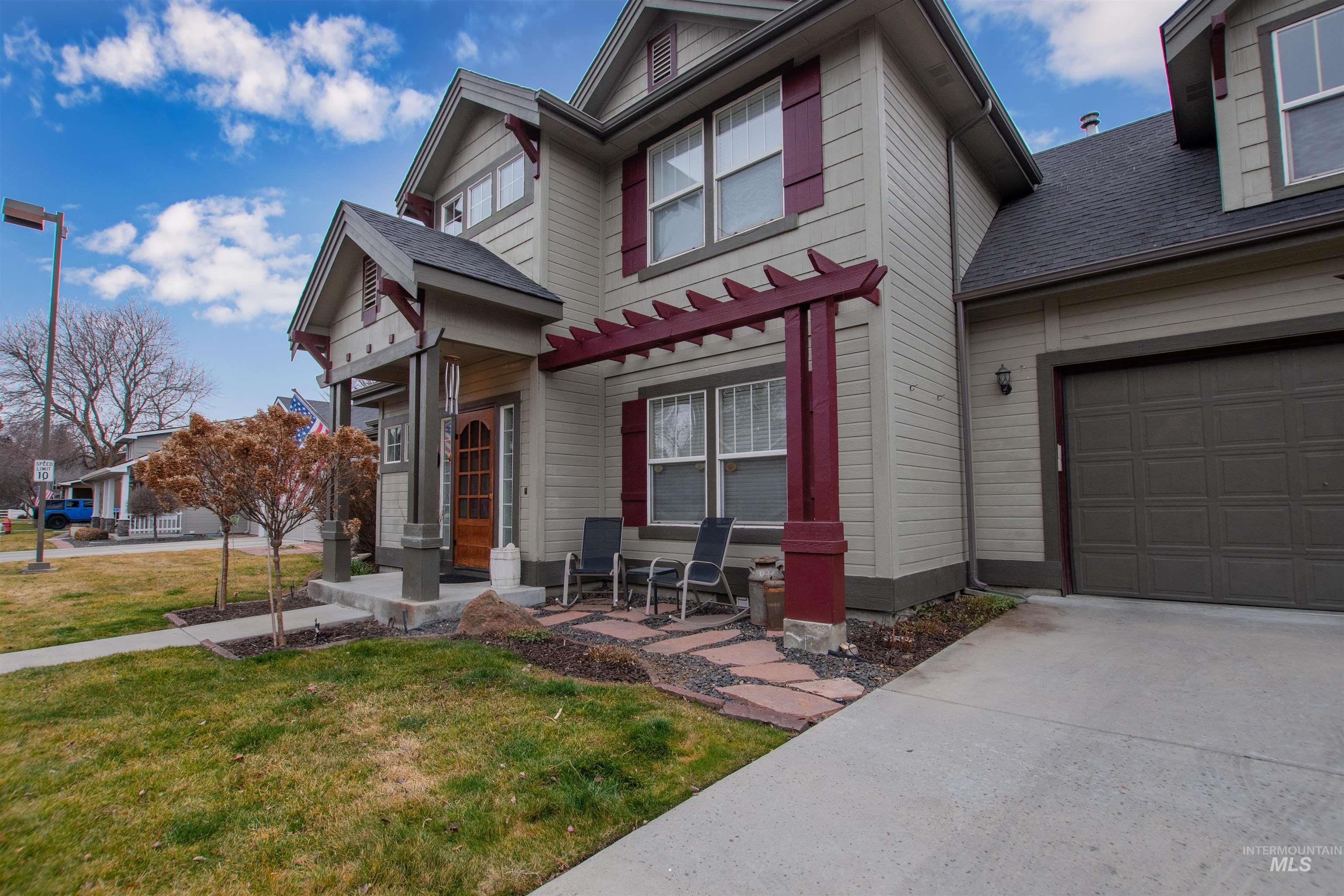 View of front of property featuring a front lawn, a shingled roof, concrete driveway, and an attached garage
