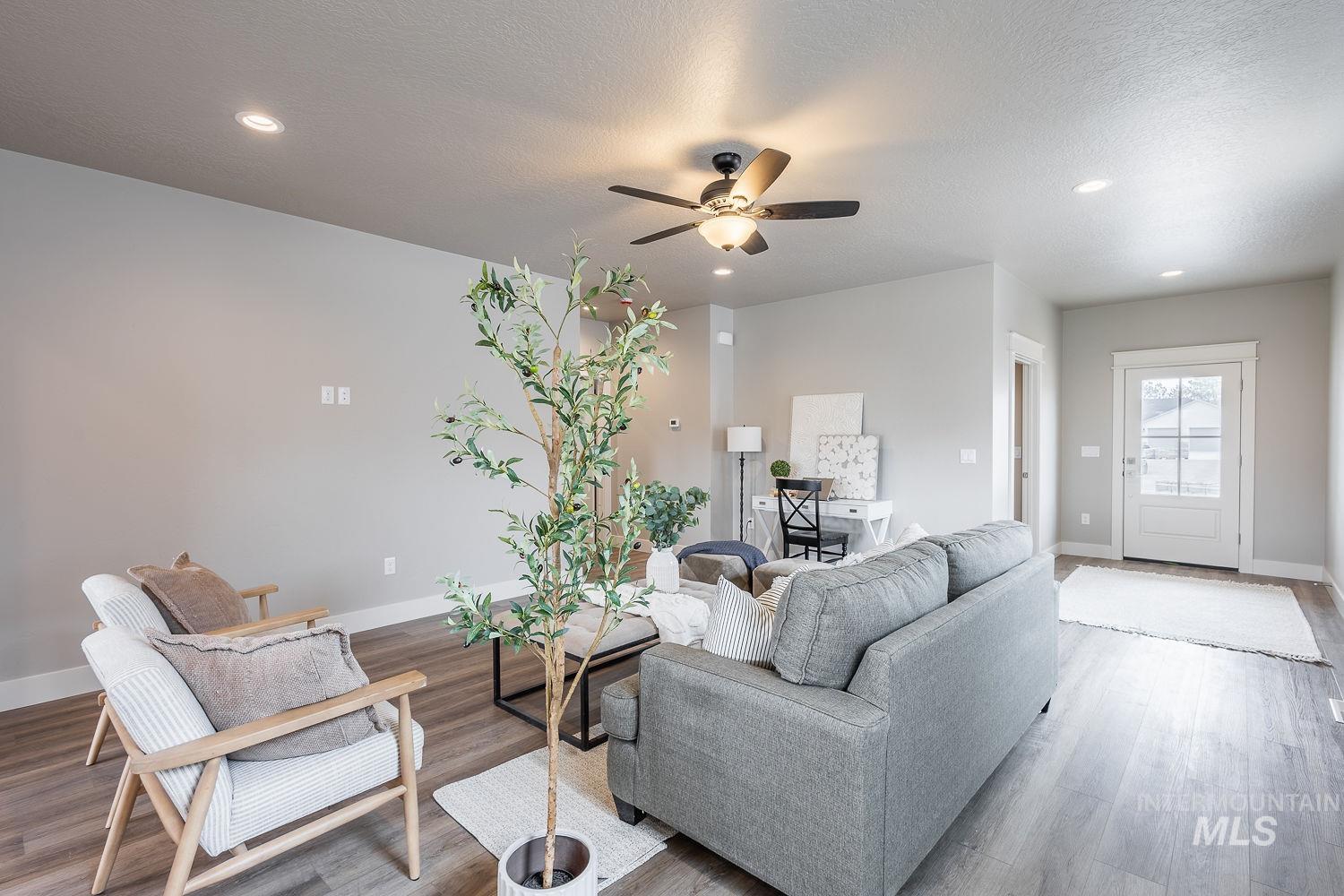 Expansive living area featuring wood-finish flooring, recessed lighting, and a ceiling fan
