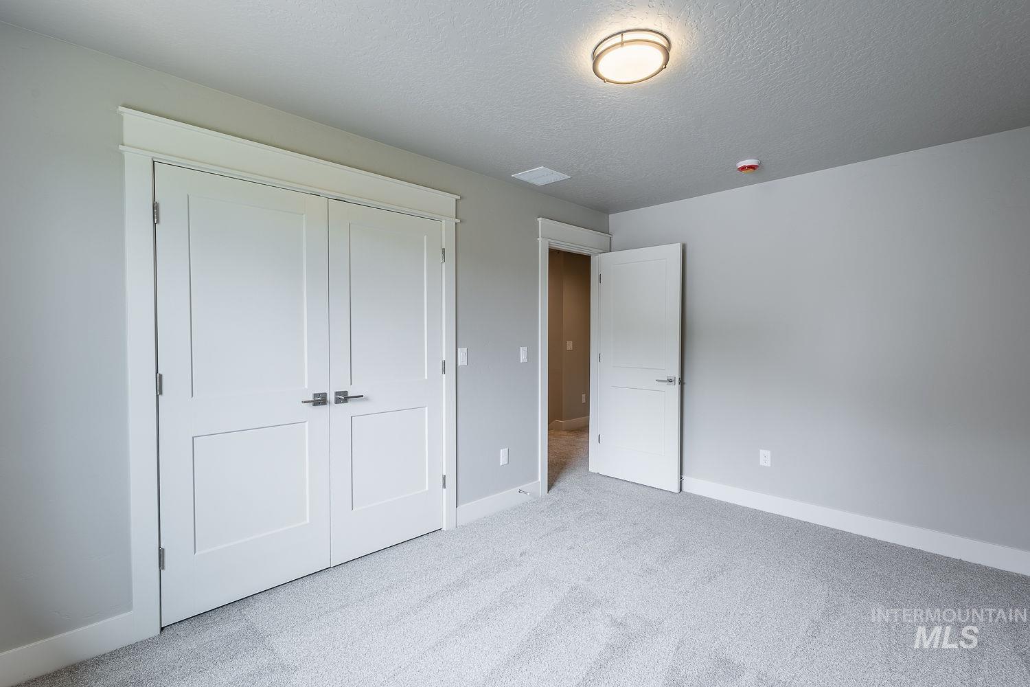 Contemporary room featuring light gray wall paint, white trim, and light gray carpet flooring