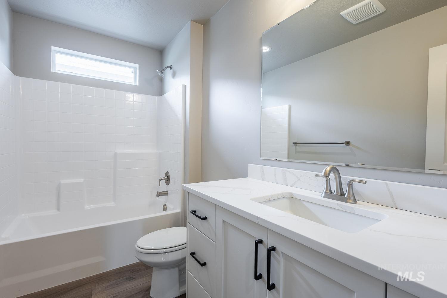 Bathroom featuring a white vanity with an integrated sink, brushed nickel faucet, and black cabinet hardware