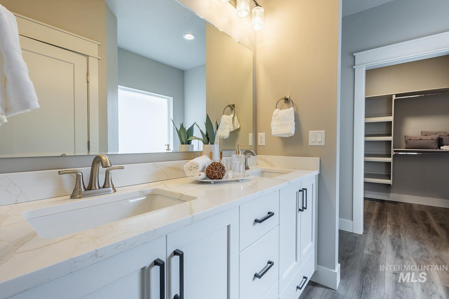 Dual vanity with white cabinetry, matte black hardware, and integrated sinks set in a stone-finish countertop