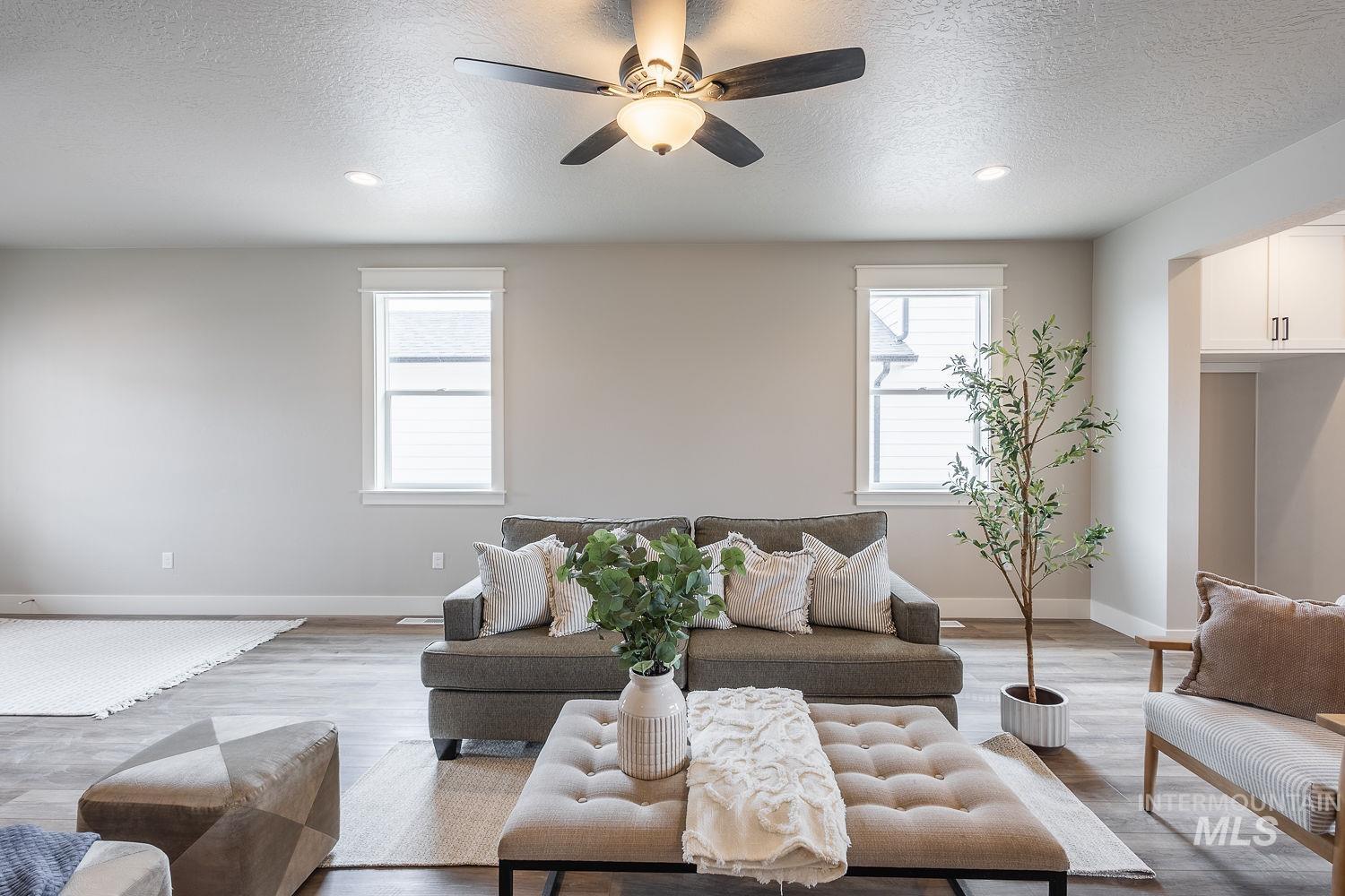 Living area featuring wood-finish flooring, recessed lighting, and a ceiling fan