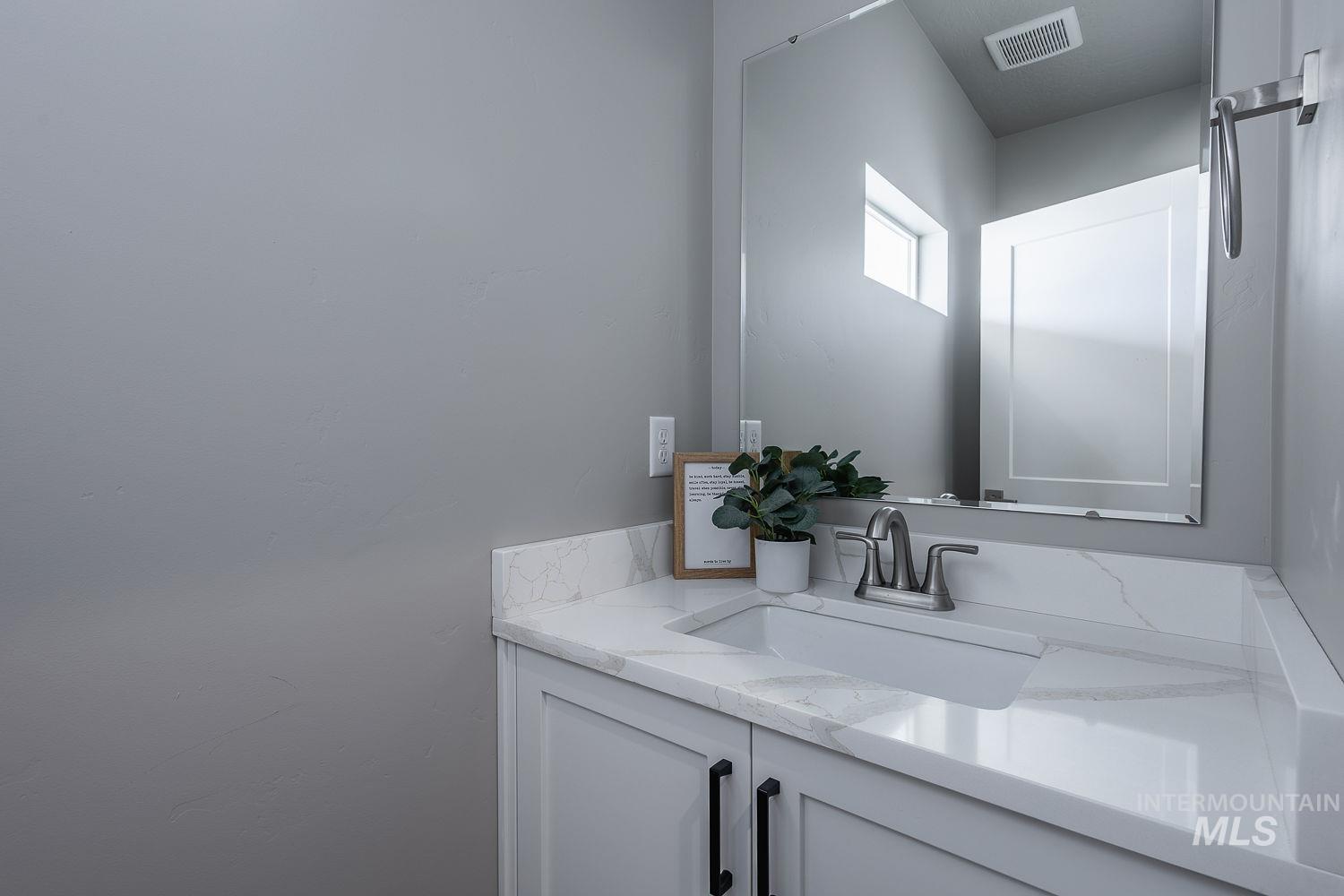 Vanity with white countertop, integrated sink, and brushed nickel faucet