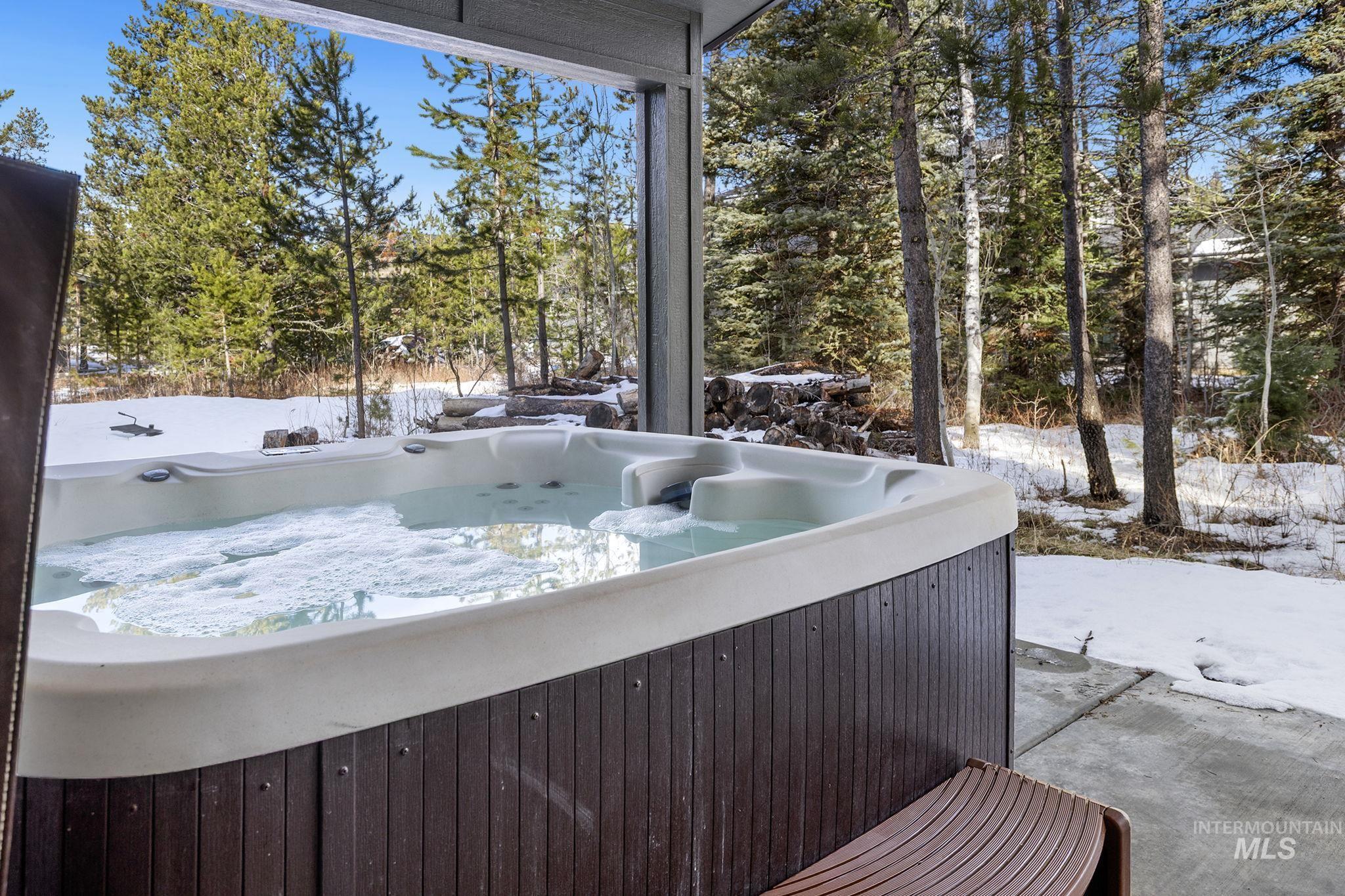 Exterior space featuring a hot tub and view of scattered trees