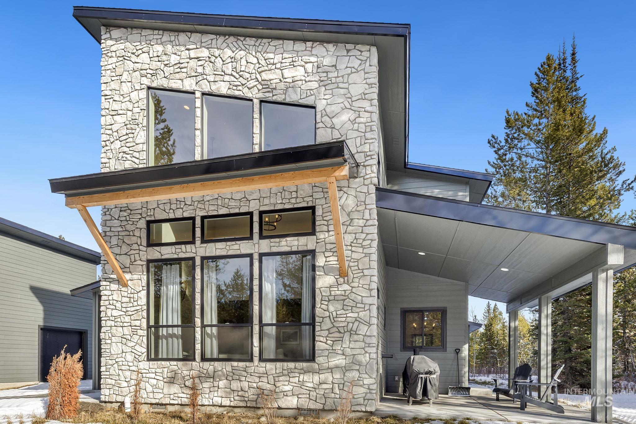 Rear view of property featuring stone siding