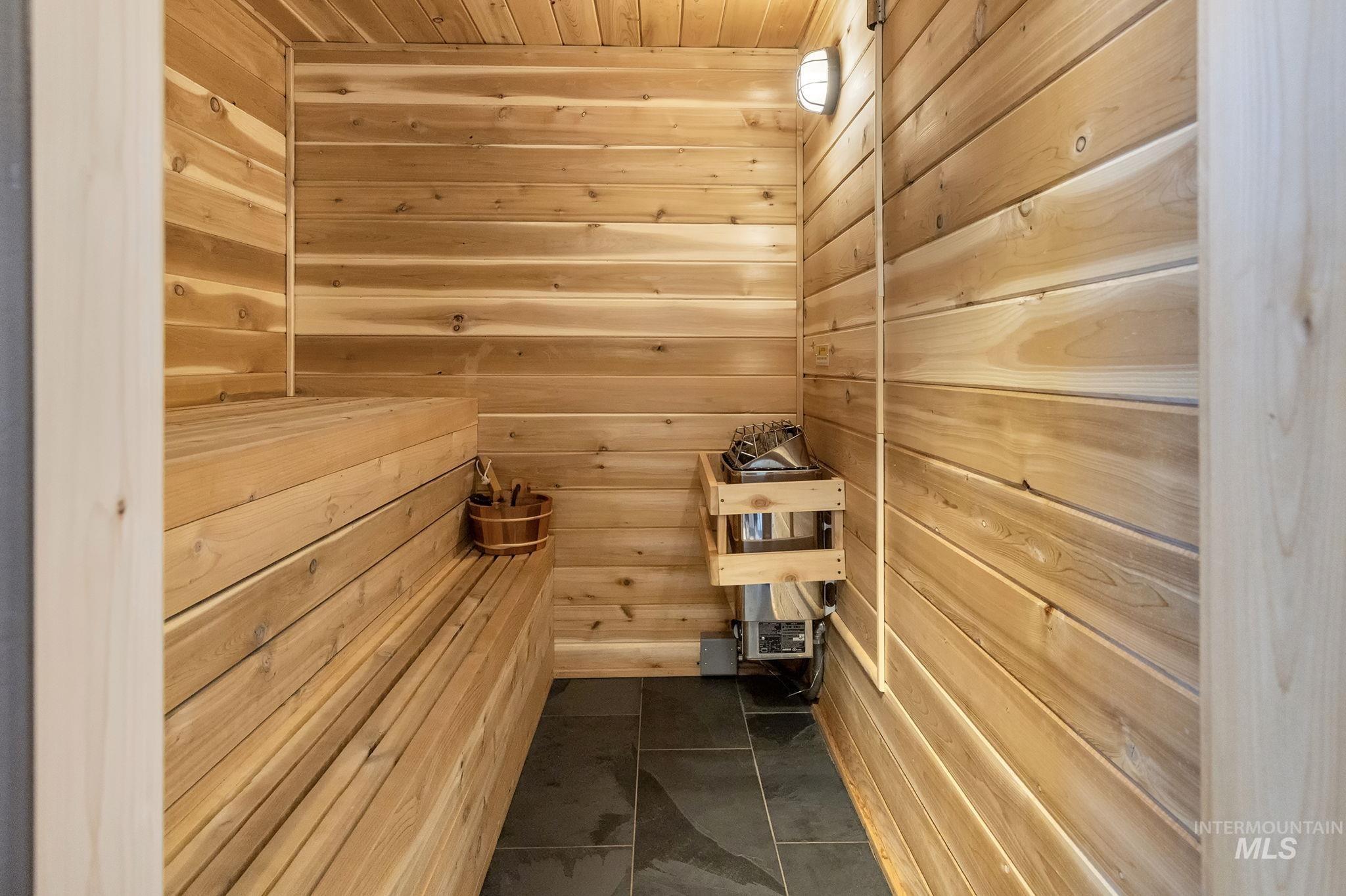 Relaxing sauna / steam room with wood walls, wooden ceiling, and tile patterned flooring