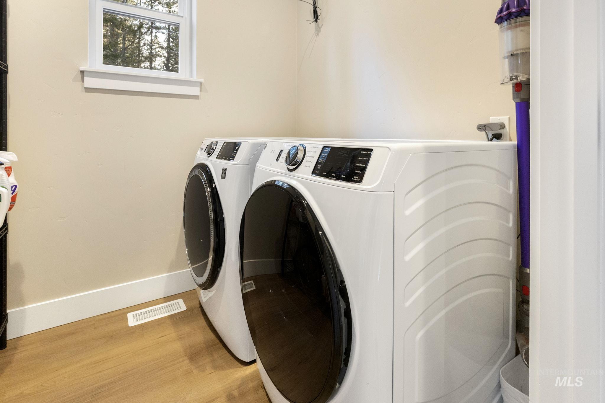 Laundry room with wood finished floors and independent washer and dryer