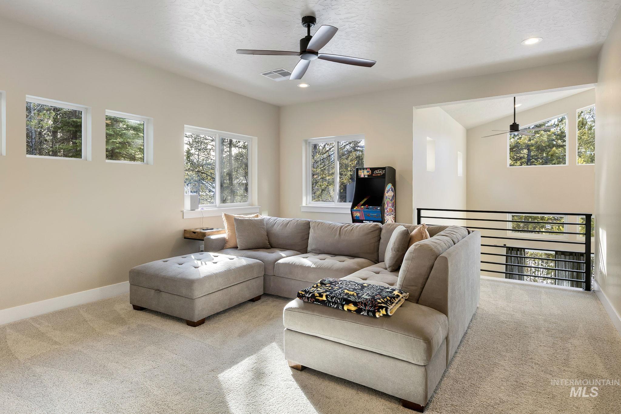Carpeted living area featuring a ceiling fan and recessed lighting