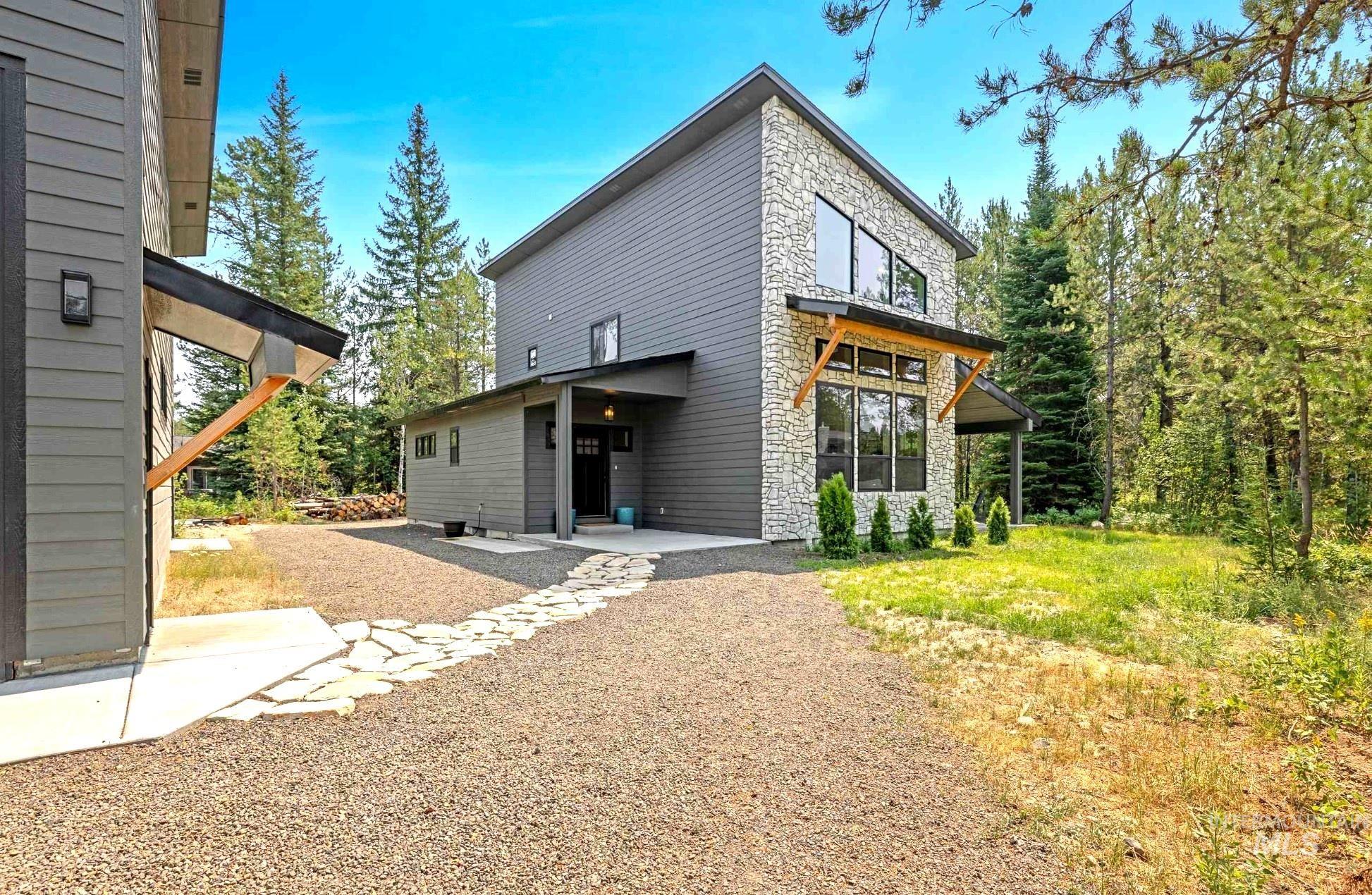 View of side of home with stone siding and a patio area