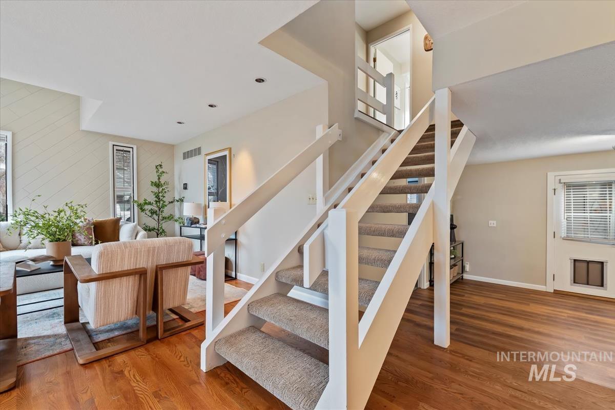 Staircase with wood finished floors and baseboards