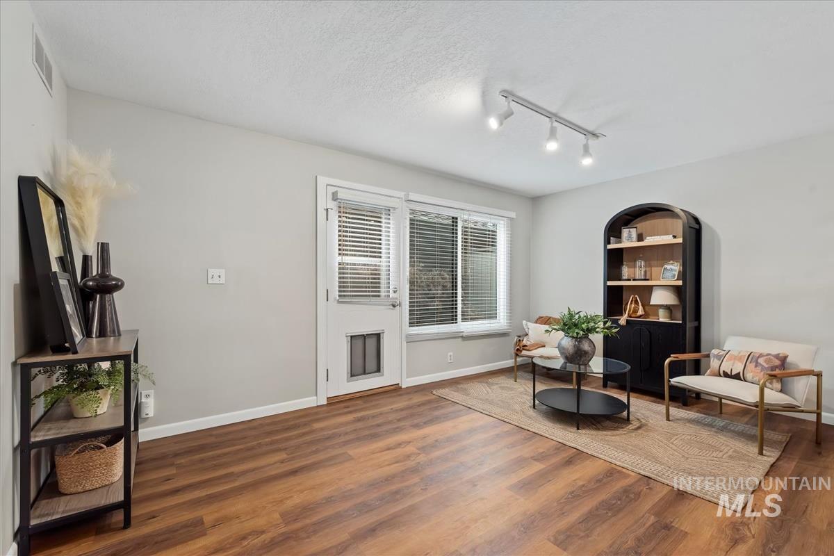 Sitting room featuring wood finished floors, track lighting, and a textured ceiling